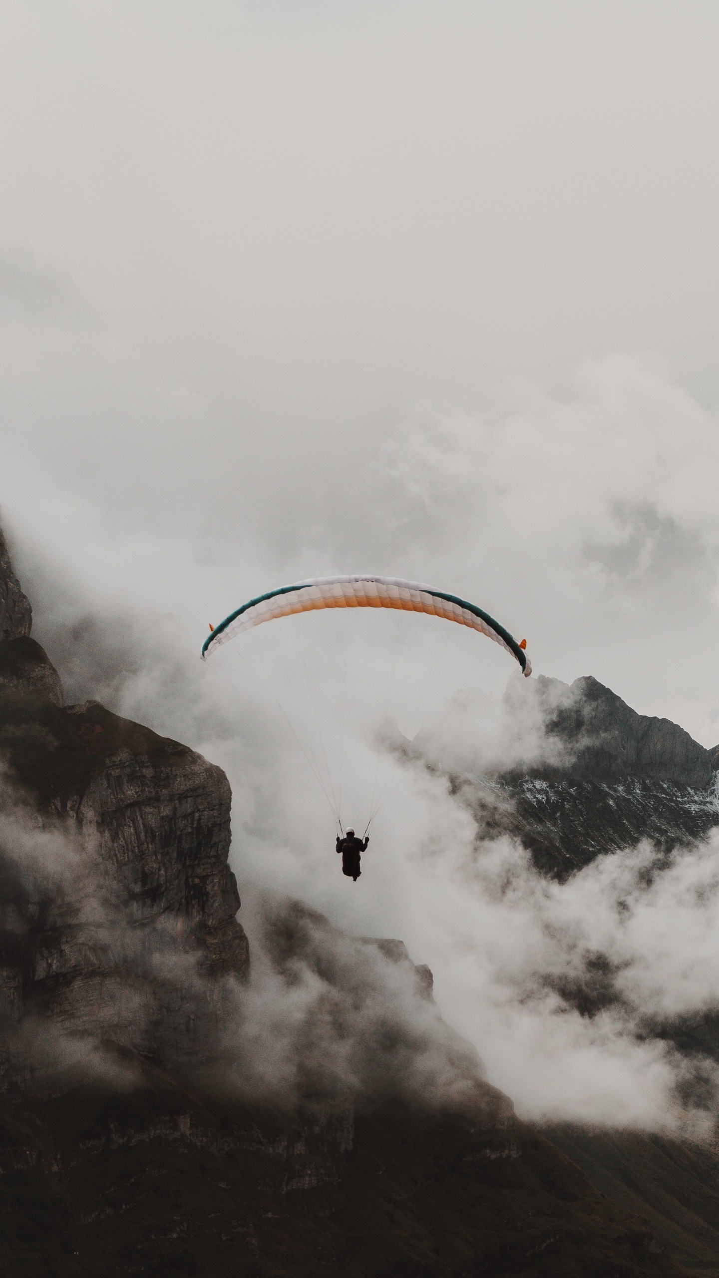 Person Reitet Fallschirm Über Schneebedeckten Berg. Wallpaper in 1440x2560 Resolution
