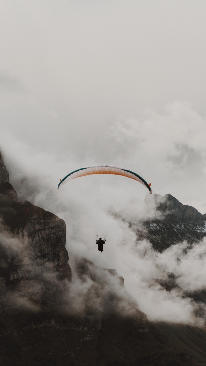 Person Reitet Fallschirm Über Schneebedeckten Berg. Wallpaper in 720x1280 Resolution