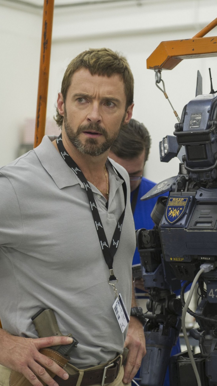 Mann im Grauen Poloshirt Steht Neben Schwarzem Motorrad. Wallpaper in 720x1280 Resolution