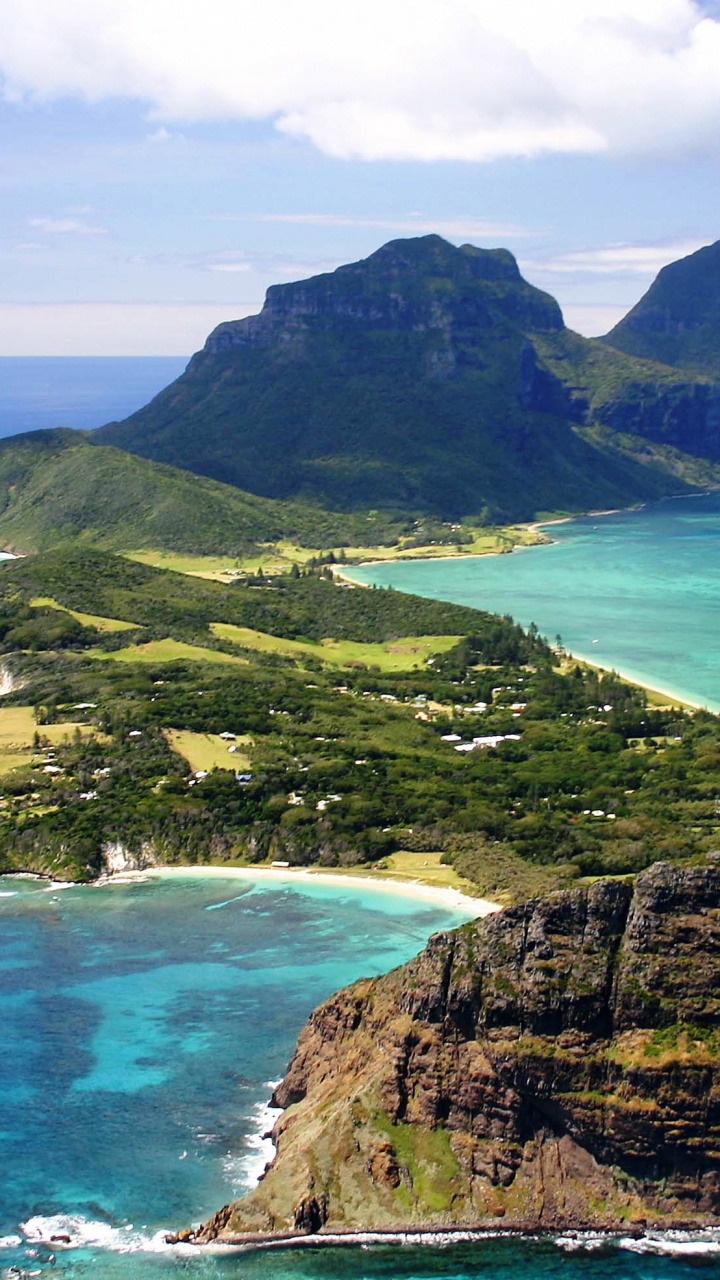 Green and Brown Mountain Beside Blue Sea Under Blue Sky During Daytime. Wallpaper in 720x1280 Resolution
