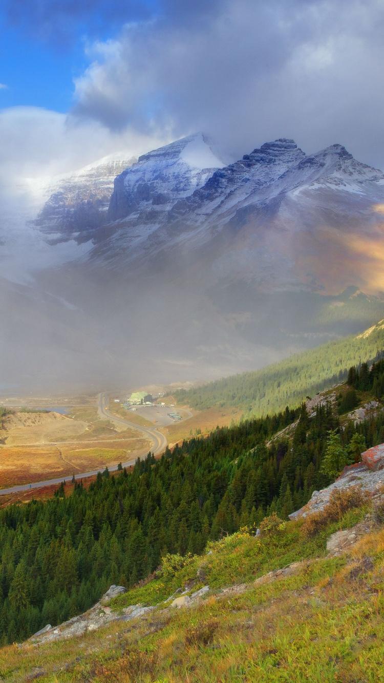 Campo de Hierba Verde y Marrón Cerca de la Montaña Bajo Nubes Blancas y Cielo Azul Durante el Día. Wallpaper in 750x1334 Resolution