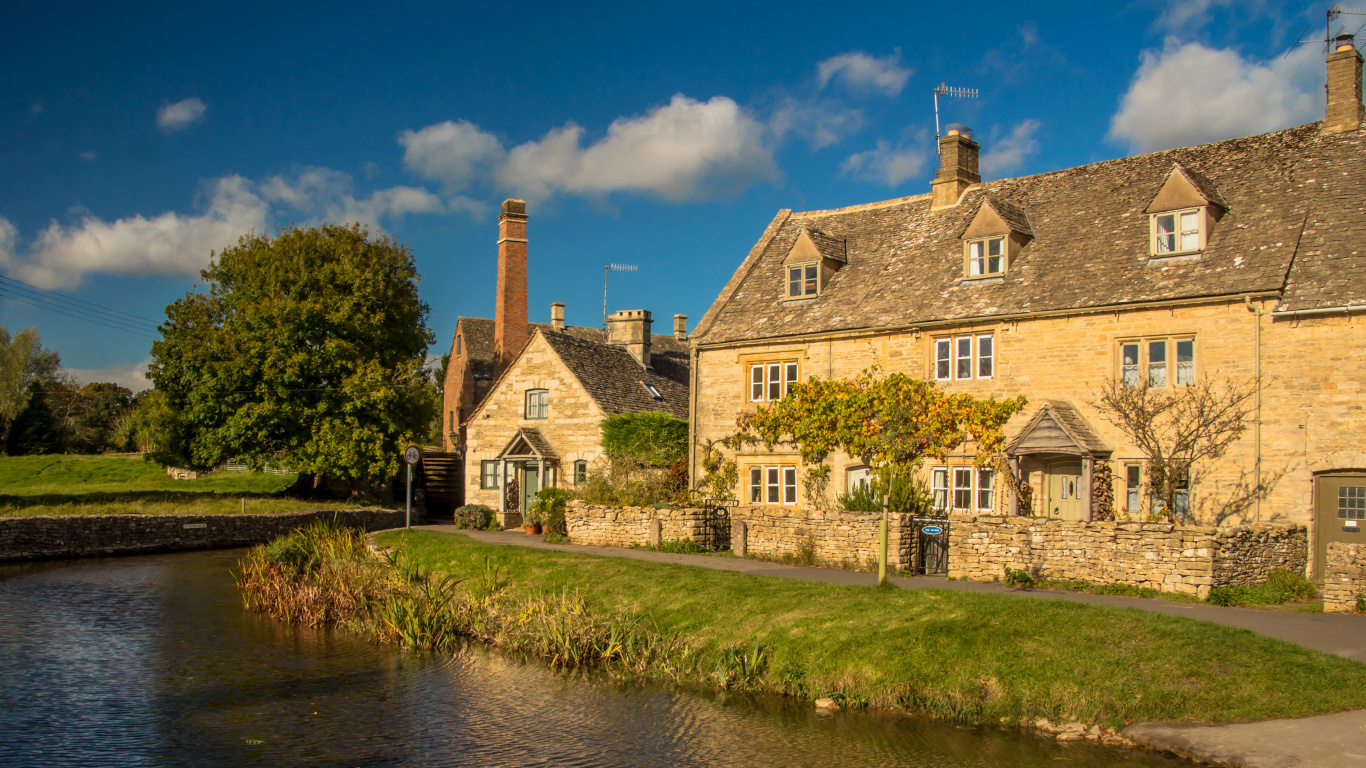 Brown Brick Building Beside River During Daytime. Wallpaper in 1366x768 Resolution