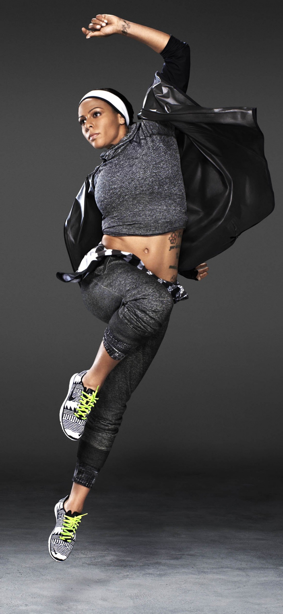 Frau in Schwarz-grauer Jacke Und Blauer Jeansim. Wallpaper in 1125x2436 Resolution