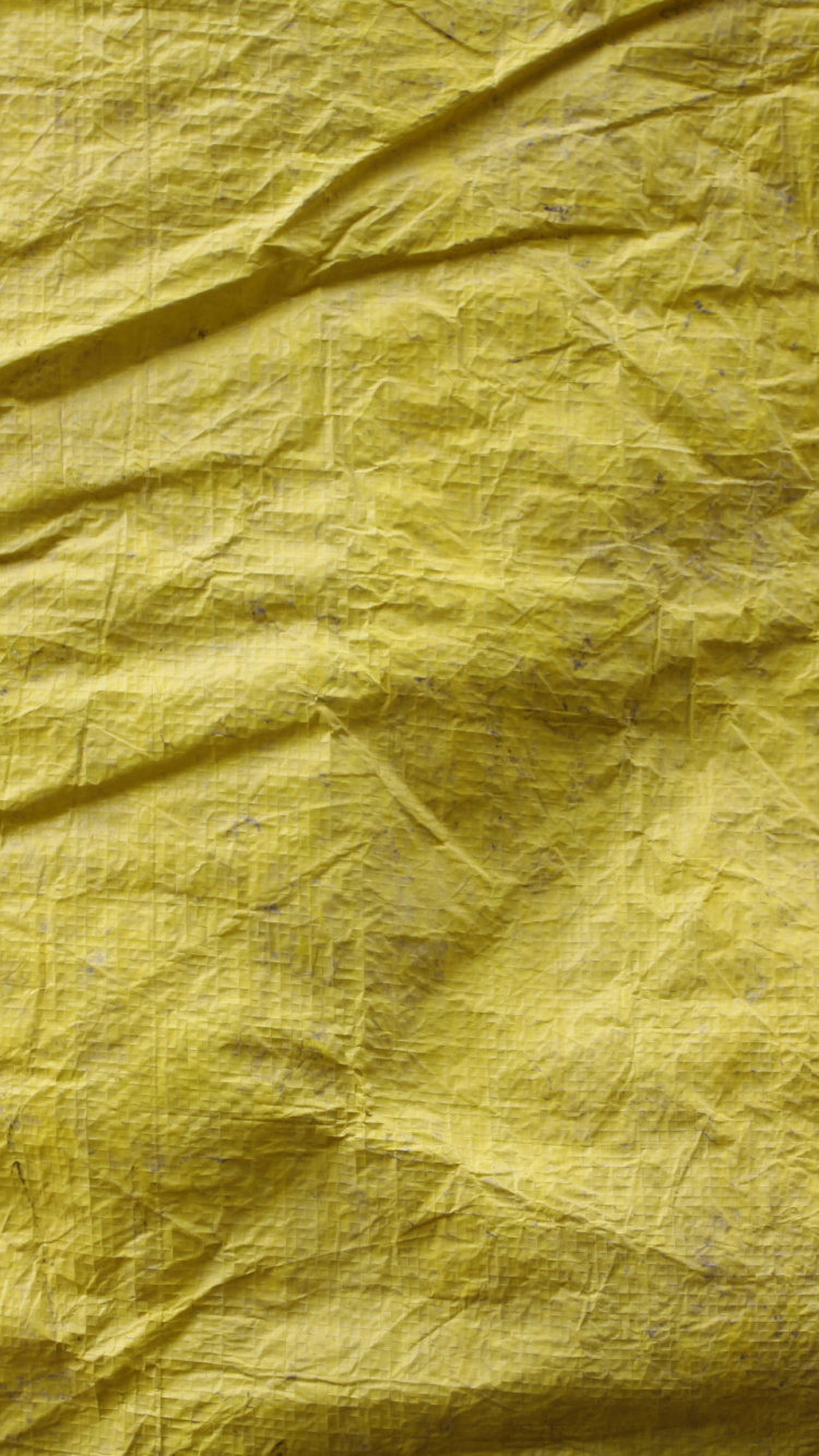 Gelbes Textil Auf Braunem Holztisch. Wallpaper in 750x1334 Resolution