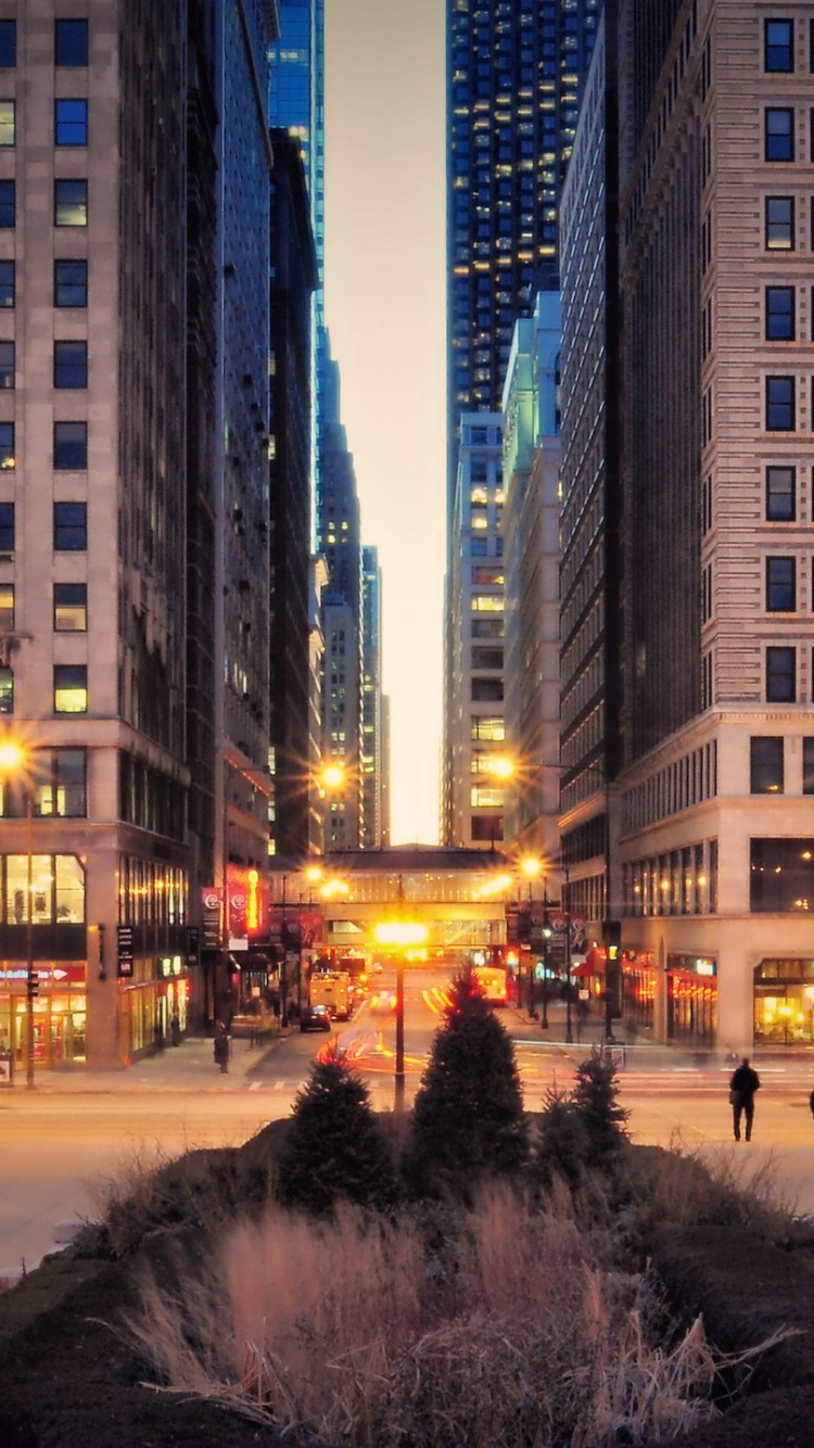 People Walking on Sidewalk Near High Rise Buildings During Night Time. Wallpaper in 750x1334 Resolution