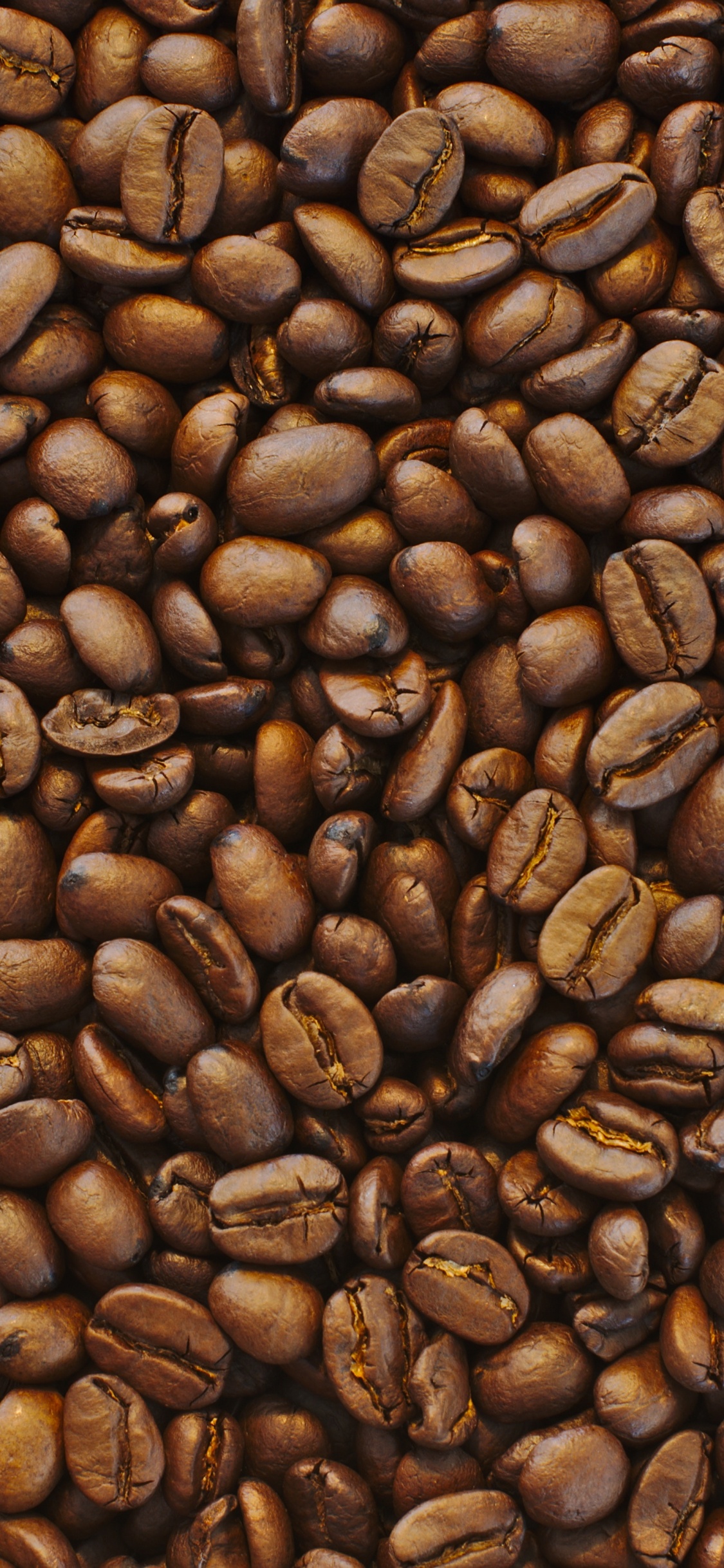 Brown Coffee Beans on Black Surface. Wallpaper in 1125x2436 Resolution