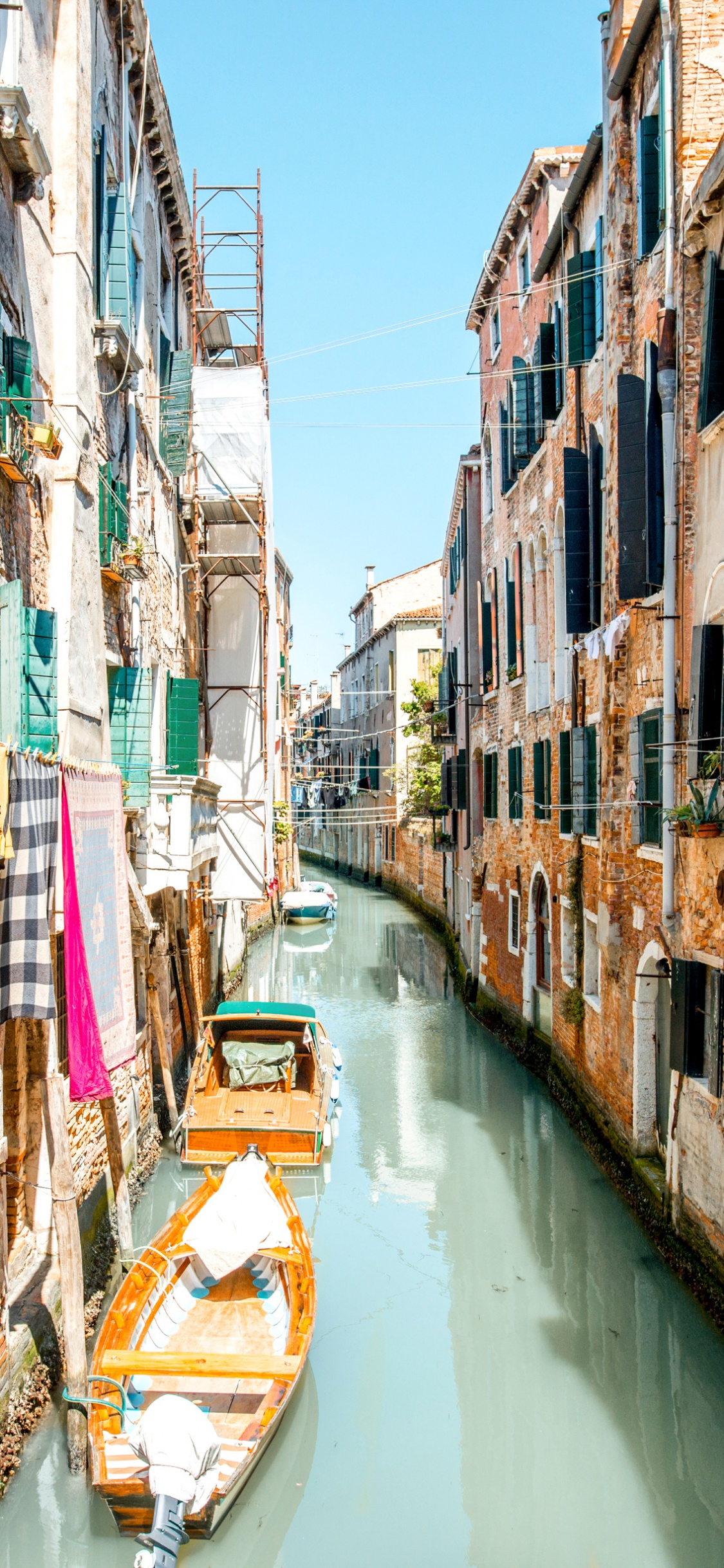 Boat on River Between Buildings During Daytime. Wallpaper in 1125x2436 Resolution