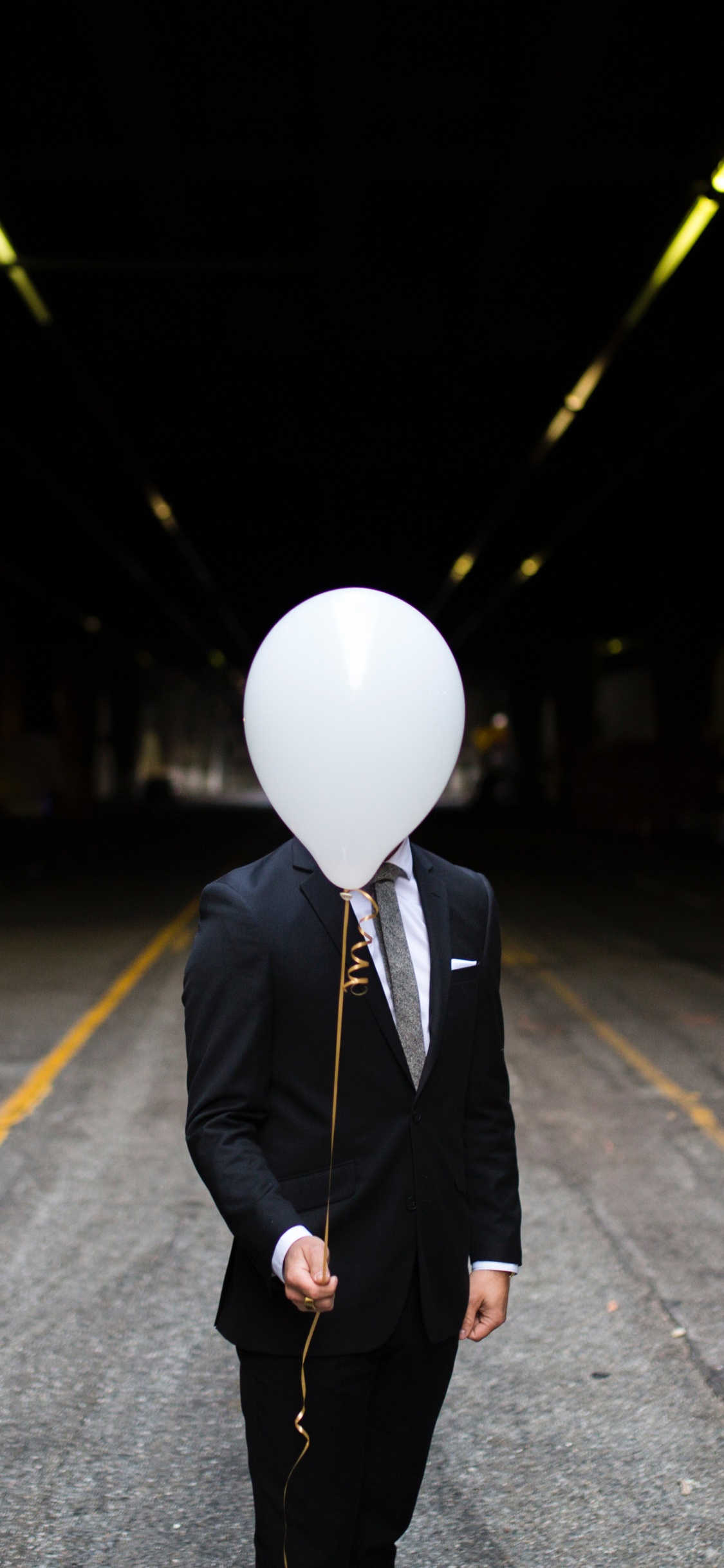 Homme en Manteau Noir et Pantalon Debout Sur la Route Pendant la Nuit. Wallpaper in 1125x2436 Resolution