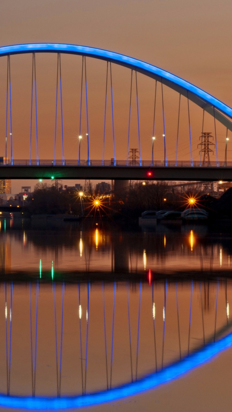 Blaue Brücke Über Wasser Während Der Nacht Night. Wallpaper in 750x1334 Resolution