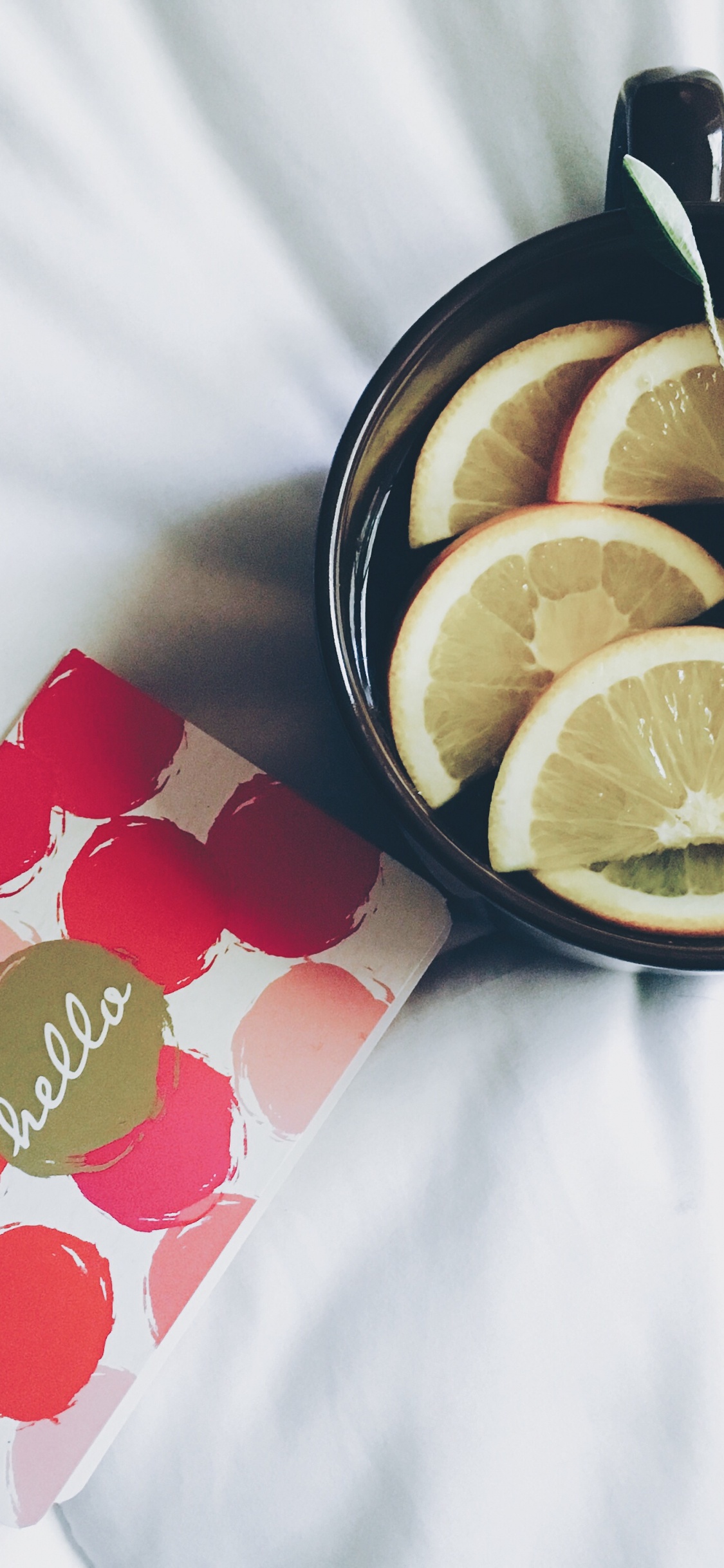 Limón en Rodajas en un Tazón de Cerámica Negro. Wallpaper in 1125x2436 Resolution