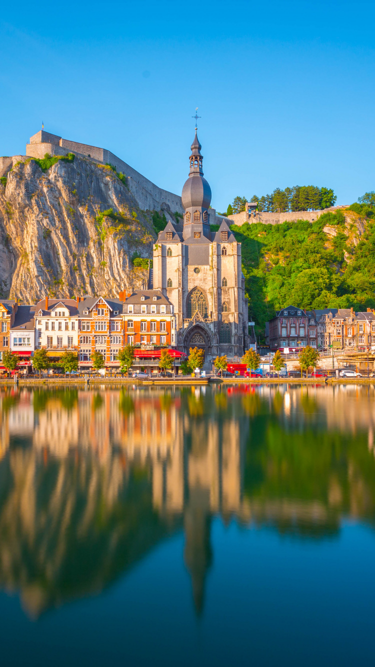 White and Brown Concrete Building Near Body of Water During Daytime. Wallpaper in 750x1334 Resolution