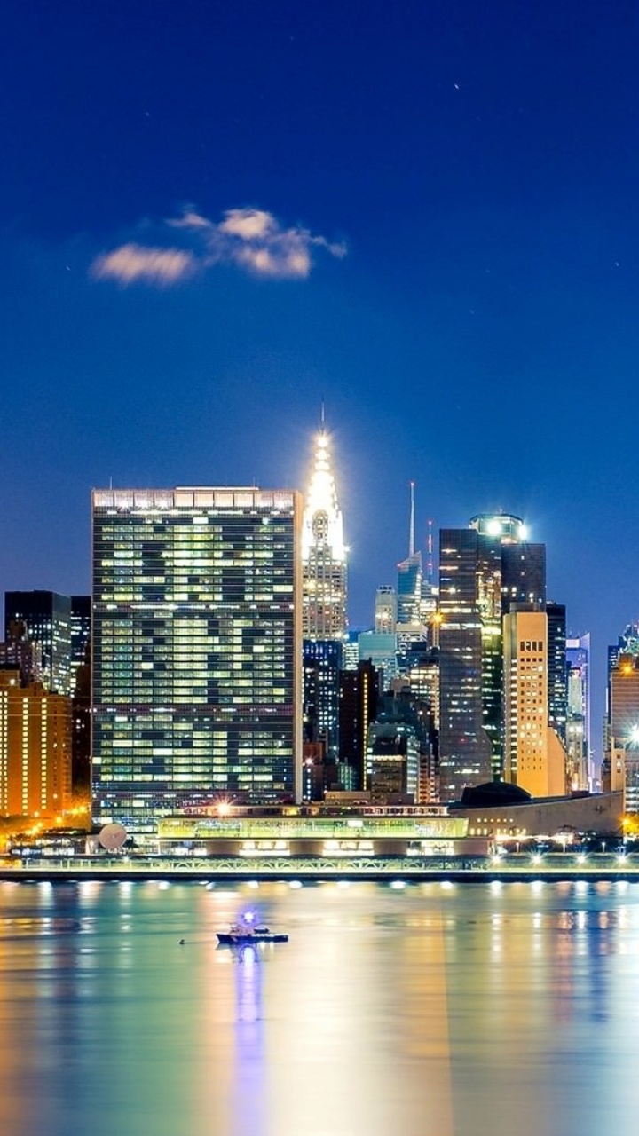 City Skyline Across Body of Water During Night Time. Wallpaper in 720x1280 Resolution