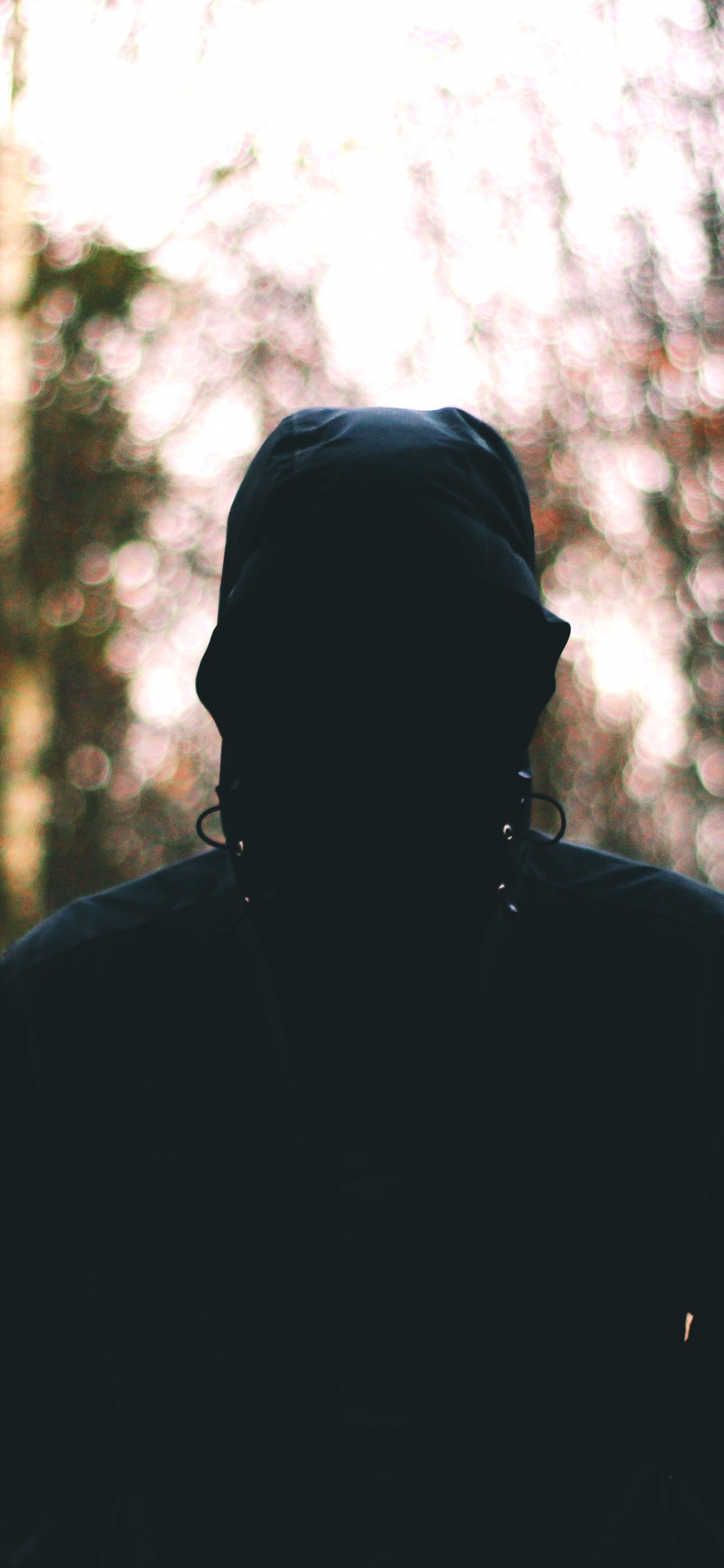 Hombre de Chaqueta Negra de Pie en el Bosque Durante el Día. Wallpaper in 1125x2436 Resolution