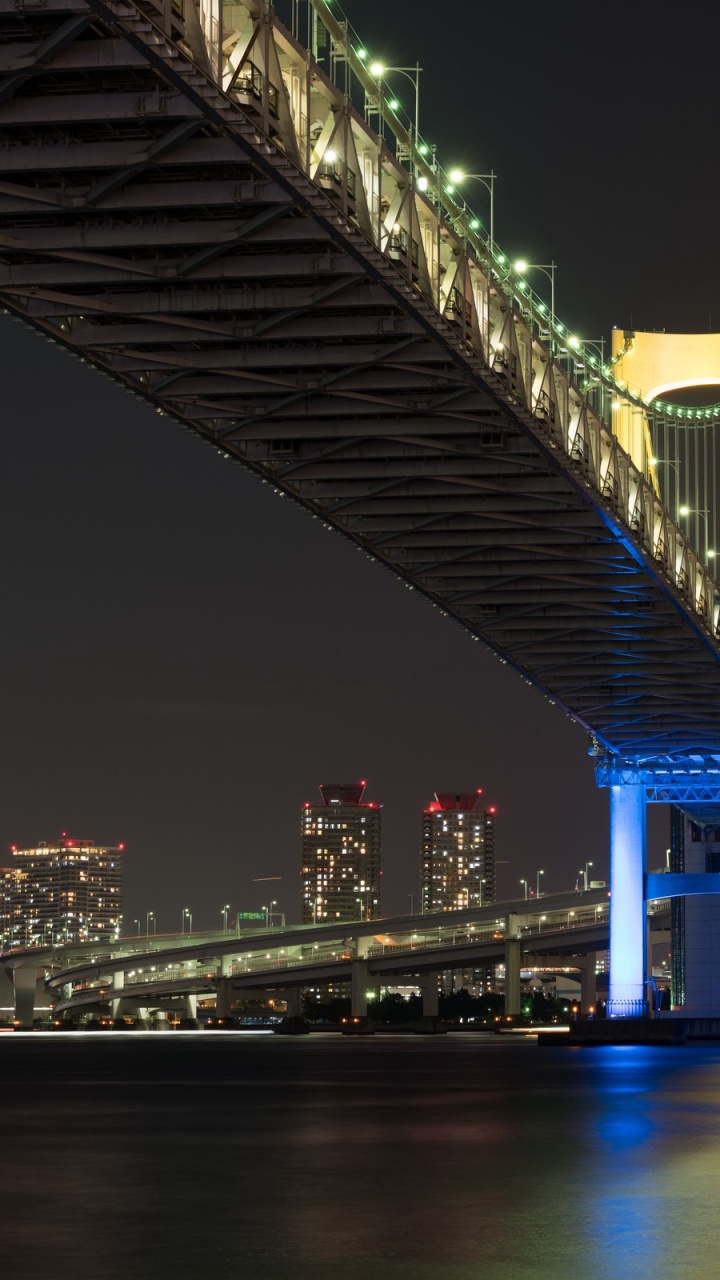 Lighted Bridge Over Water During Night Time. Wallpaper in 720x1280 Resolution