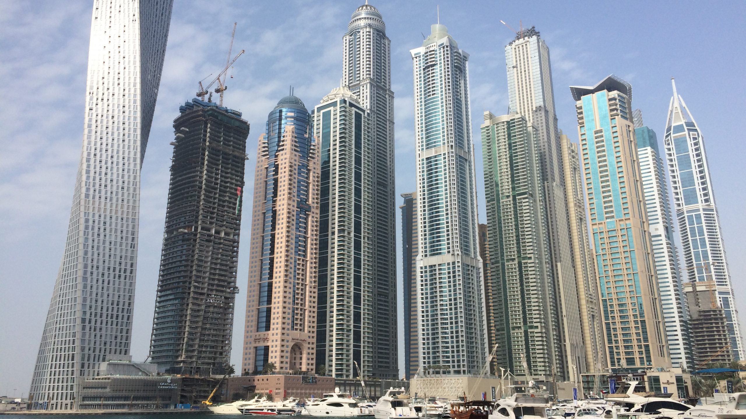 White and Blue High Rise Buildings Near Body of Water During Daytime. Wallpaper in 2560x1440 Resolution