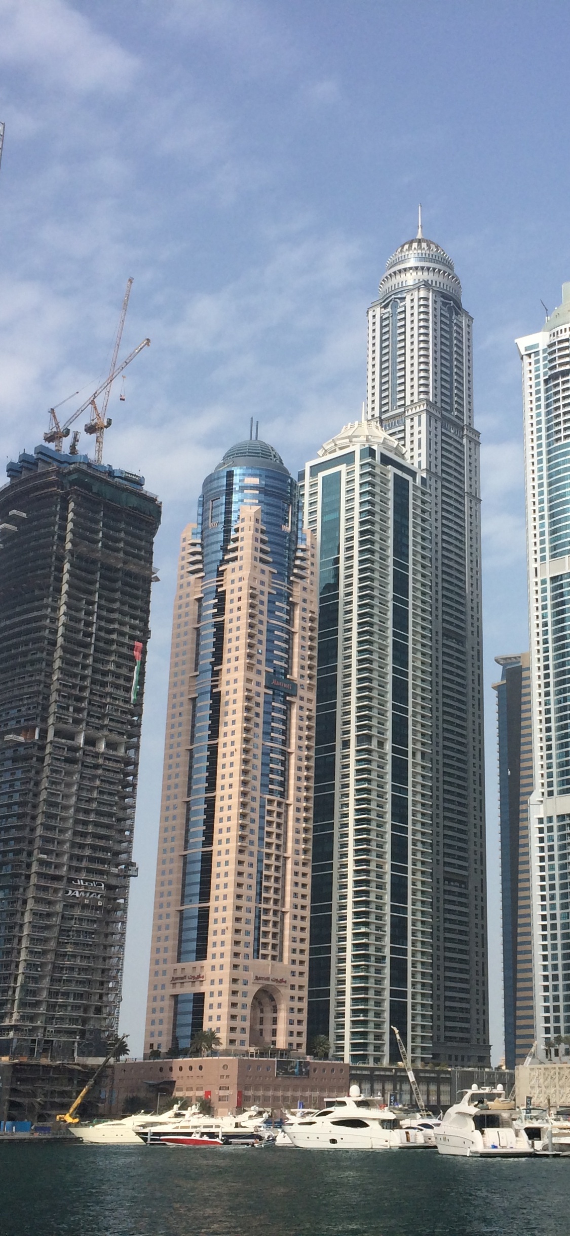 Edificios Altos Blancos y Azules Cerca Del Cuerpo de Agua Durante el Día. Wallpaper in 1125x2436 Resolution