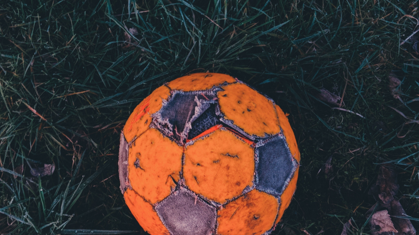 Orange and Black Soccer Ball on Green Grass. Wallpaper in 1366x768 Resolution