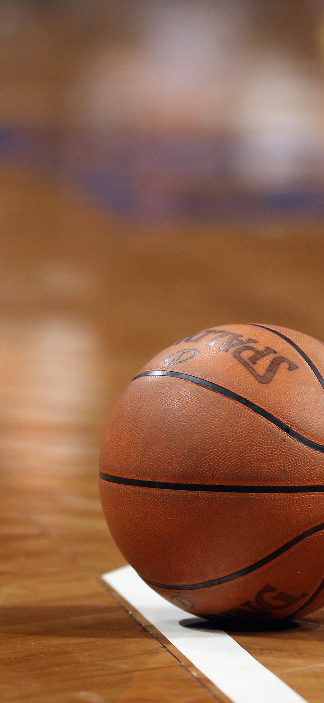 Brown Basketball on Brown Wooden Floor. Wallpaper in 1125x2436 Resolution
