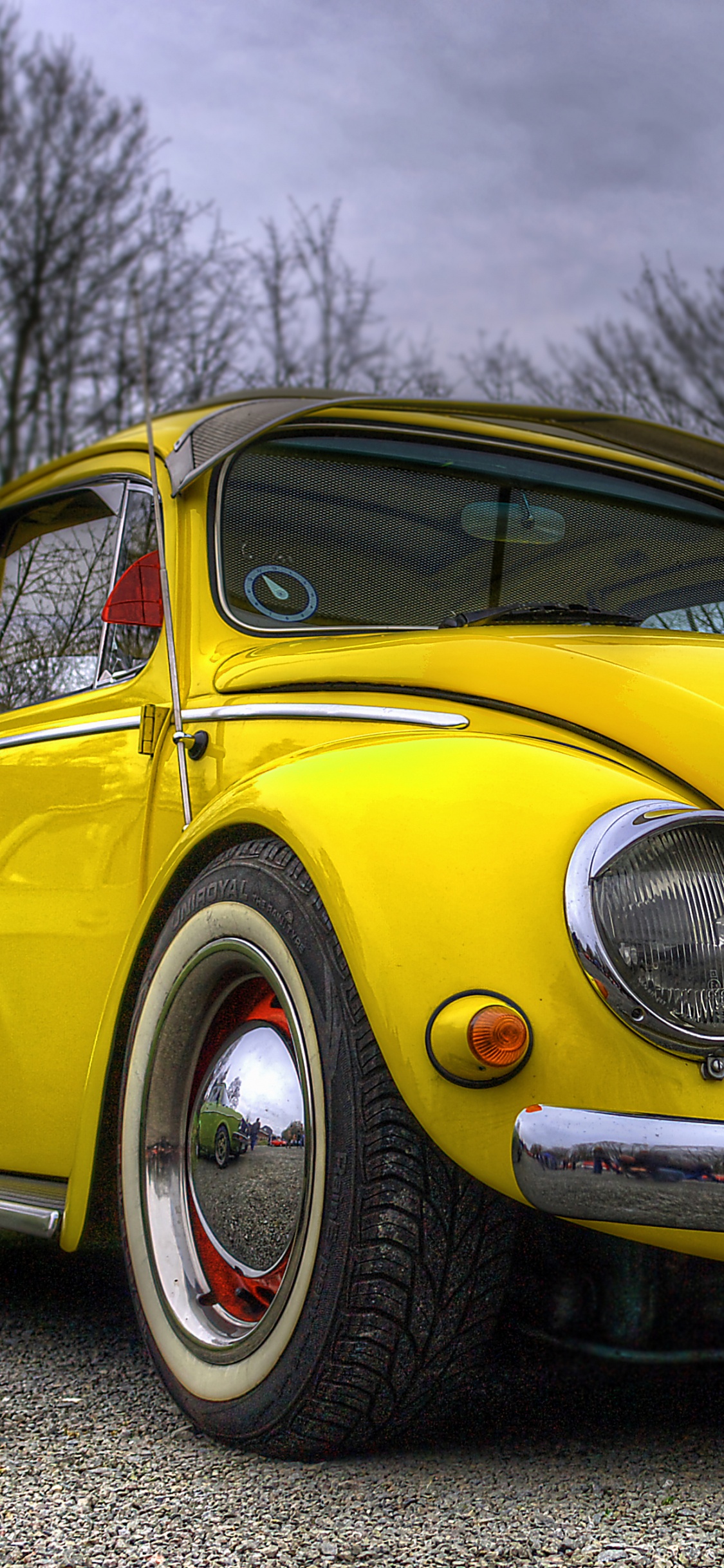 Volkswagen Beetle Amarillo Estacionado al Lado de la Carretera. Wallpaper in 1125x2436 Resolution