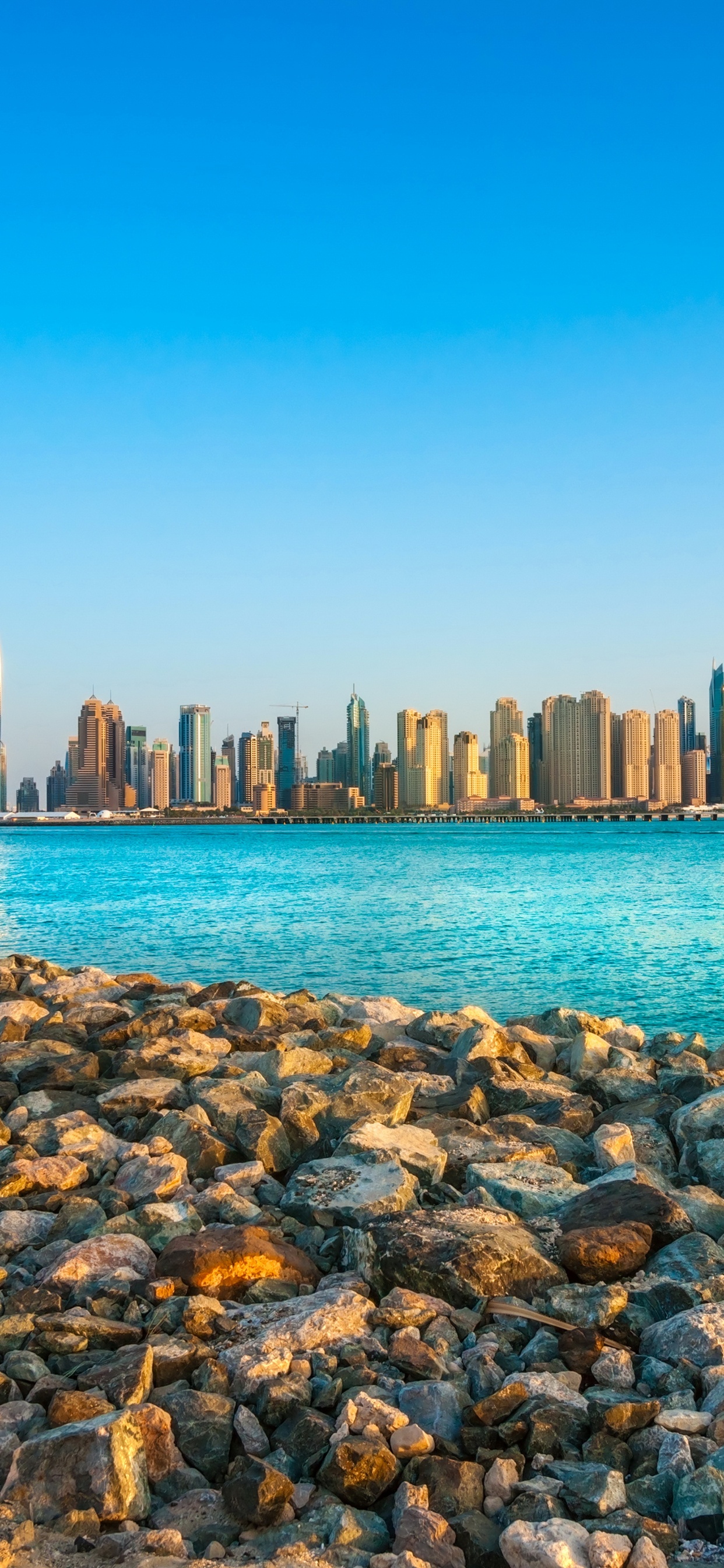 Rocas Marrones en la Orilla Del Mar Durante el Día. Wallpaper in 1242x2688 Resolution
