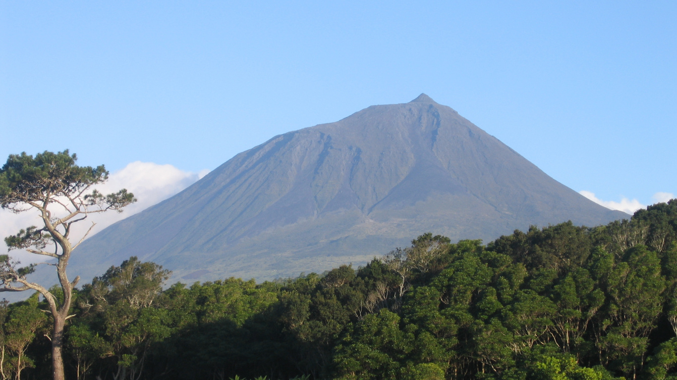 Grüne Bäume in Der Nähe Des Berges Unter Blauem Himmel Tagsüber. Wallpaper in 1366x768 Resolution