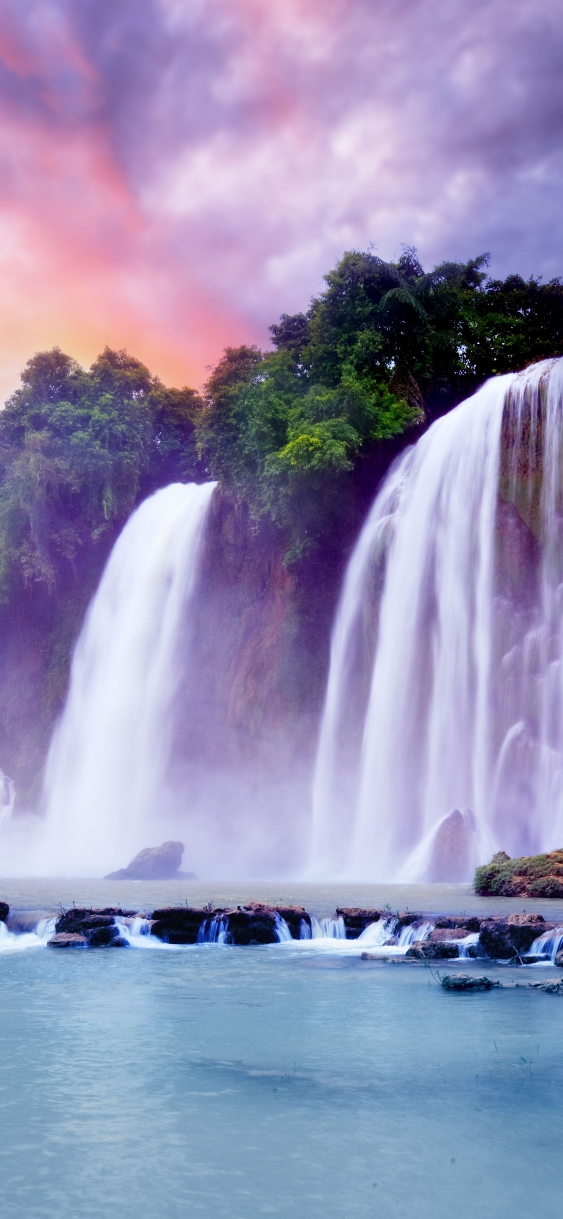 Waterfalls Near Green Trees Under Cloudy Sky During Daytime. Wallpaper in 1125x2436 Resolution