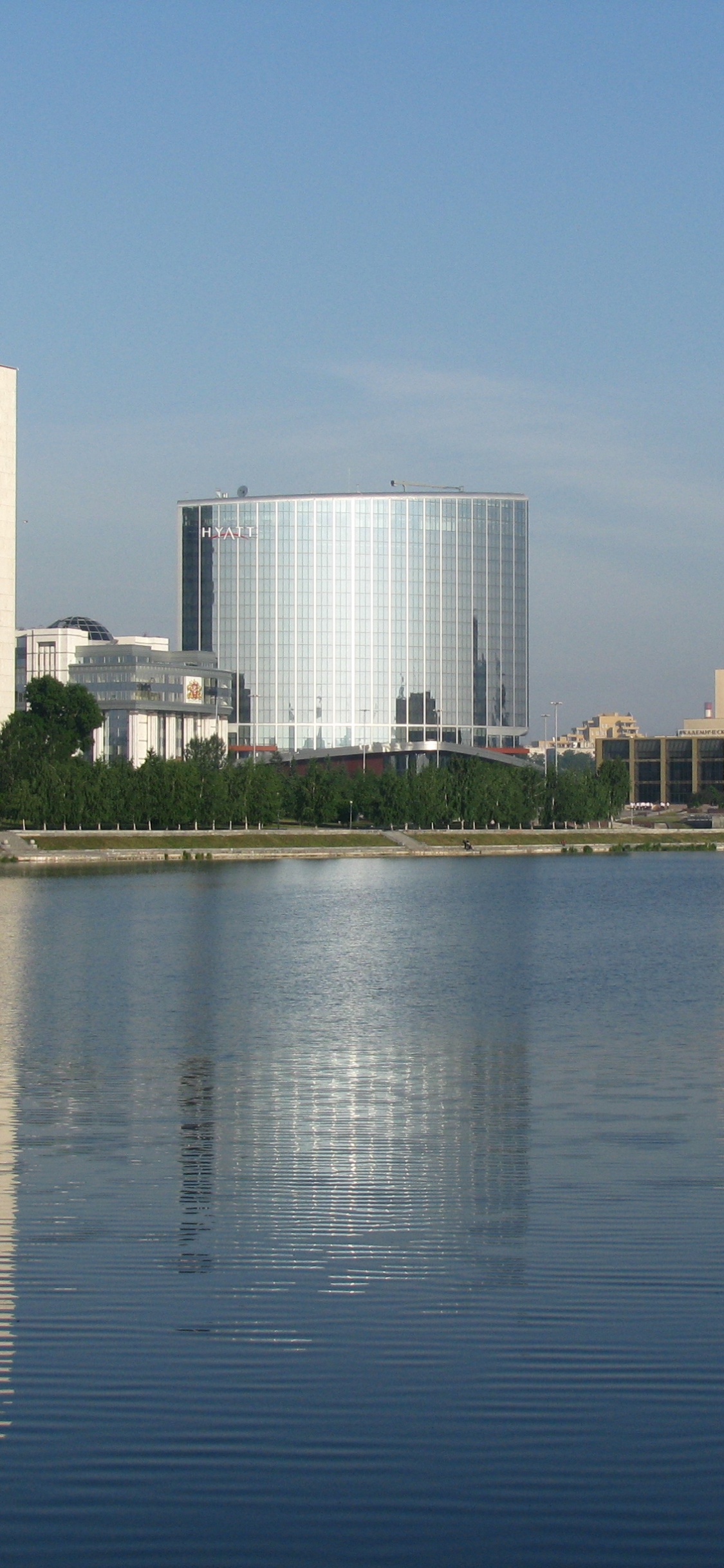 City Skyline Across Body of Water During Daytime. Wallpaper in 1125x2436 Resolution