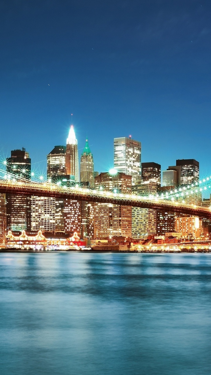 Lighted Bridge Over Water During Night Time. Wallpaper in 720x1280 Resolution