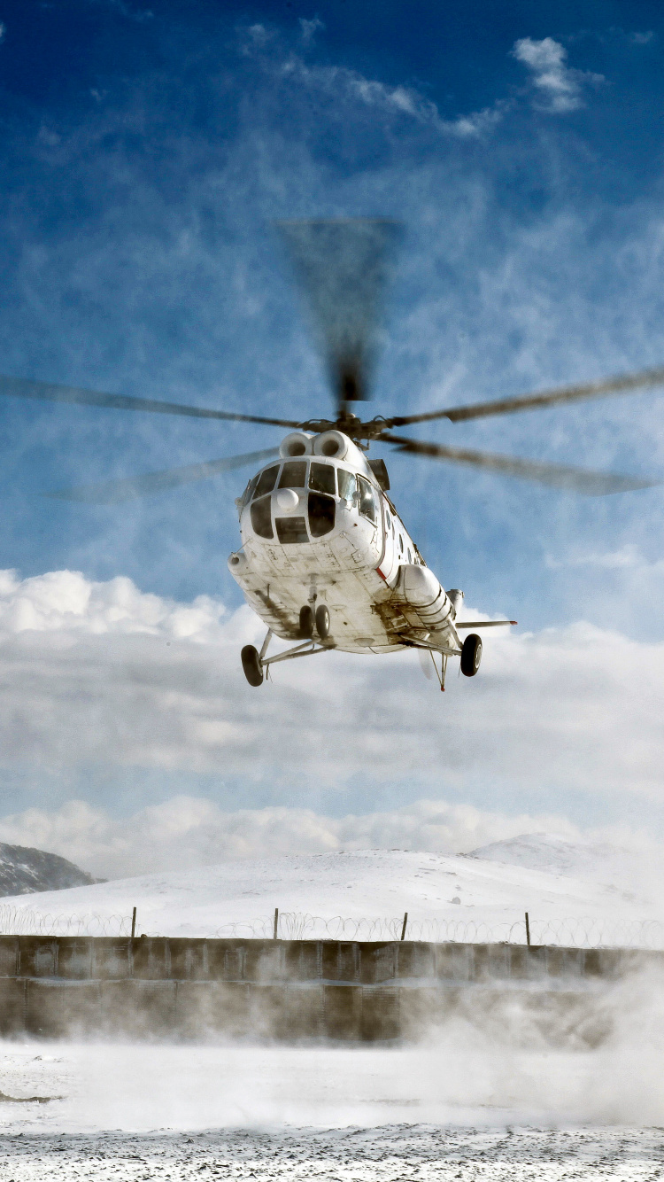 White and Black Helicopter Flying Over Snow Covered Mountain During Daytime. Wallpaper in 750x1334 Resolution