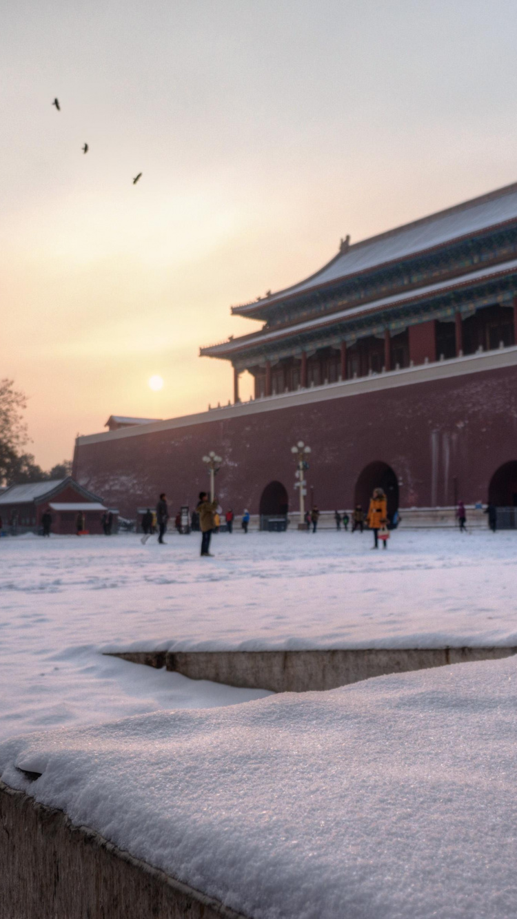 People Walking on Snow Covered Ground Near Brown Concrete Building During Daytime. Wallpaper in 750x1334 Resolution