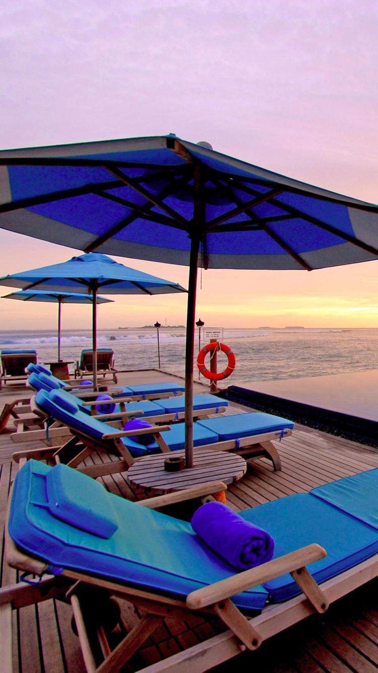 Chaises Longues Bleues et Blanches Sur la Plage Pendant le Coucher du Soleil. Wallpaper in 750x1334 Resolution