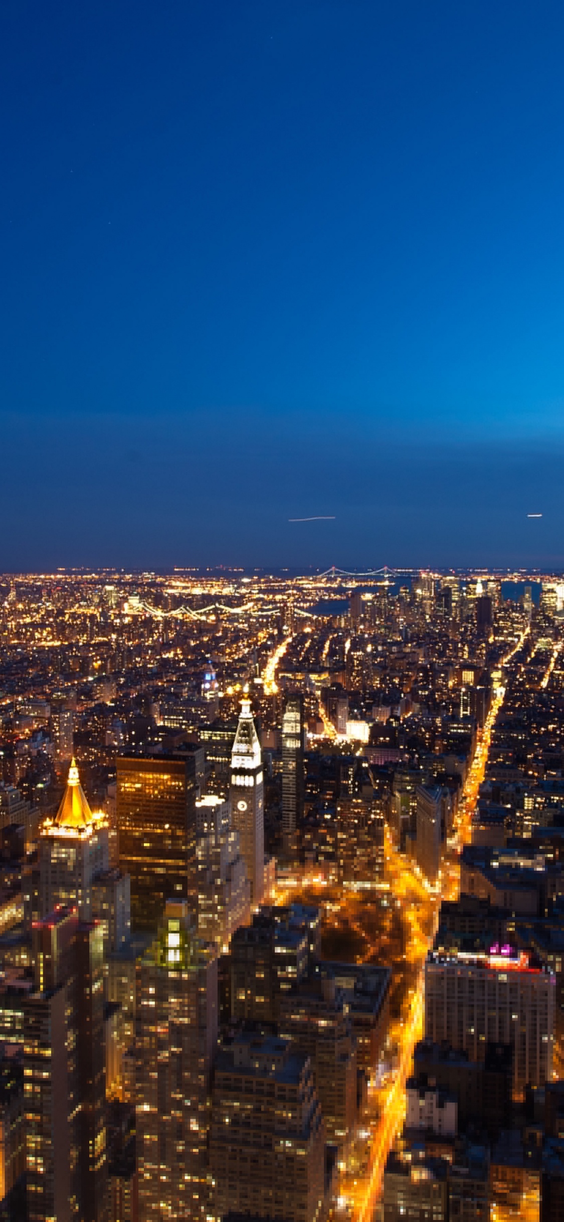 Aerial View of City Buildings During Night Time. Wallpaper in 1125x2436 Resolution