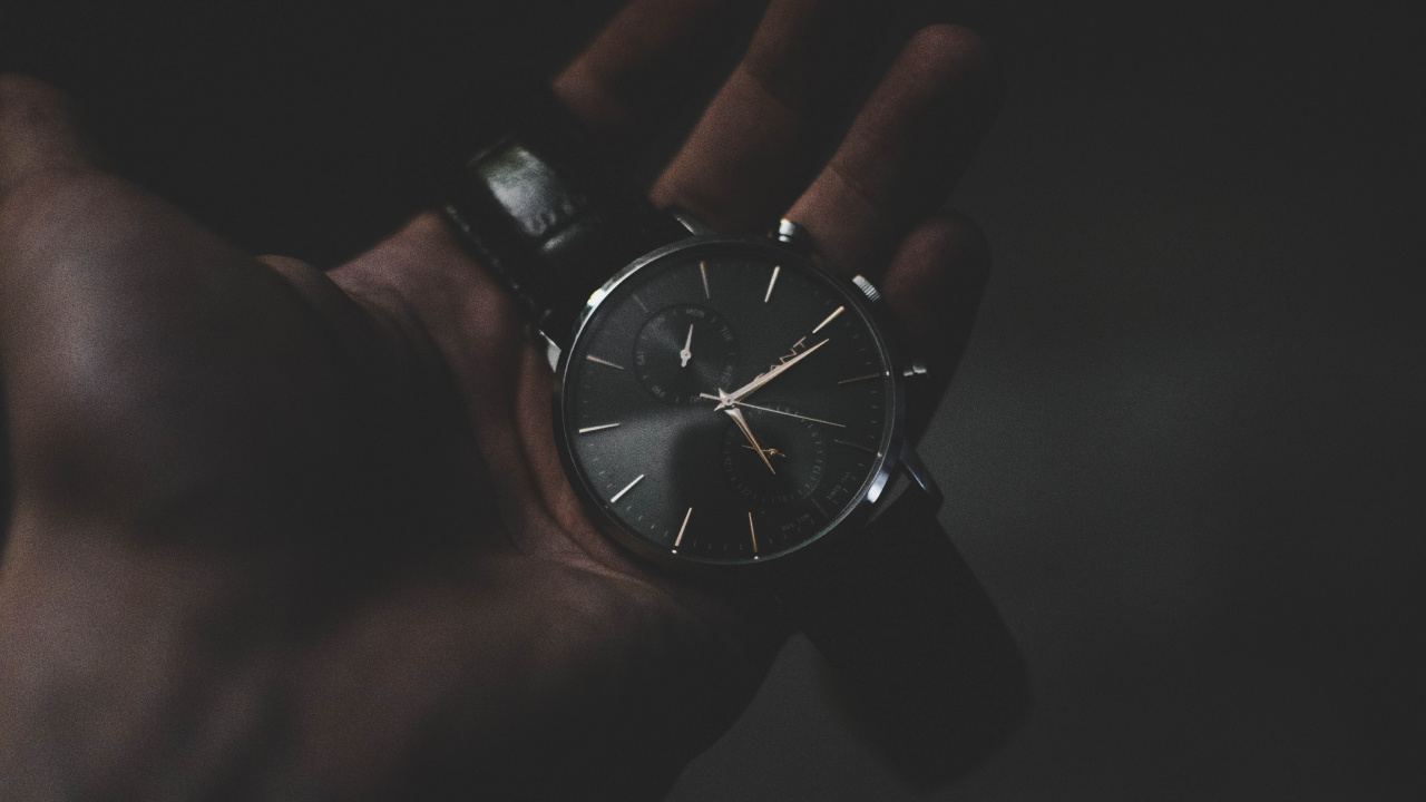 Persona Con Reloj Analógico Redondo Plateado. Wallpaper in 1280x720 Resolution