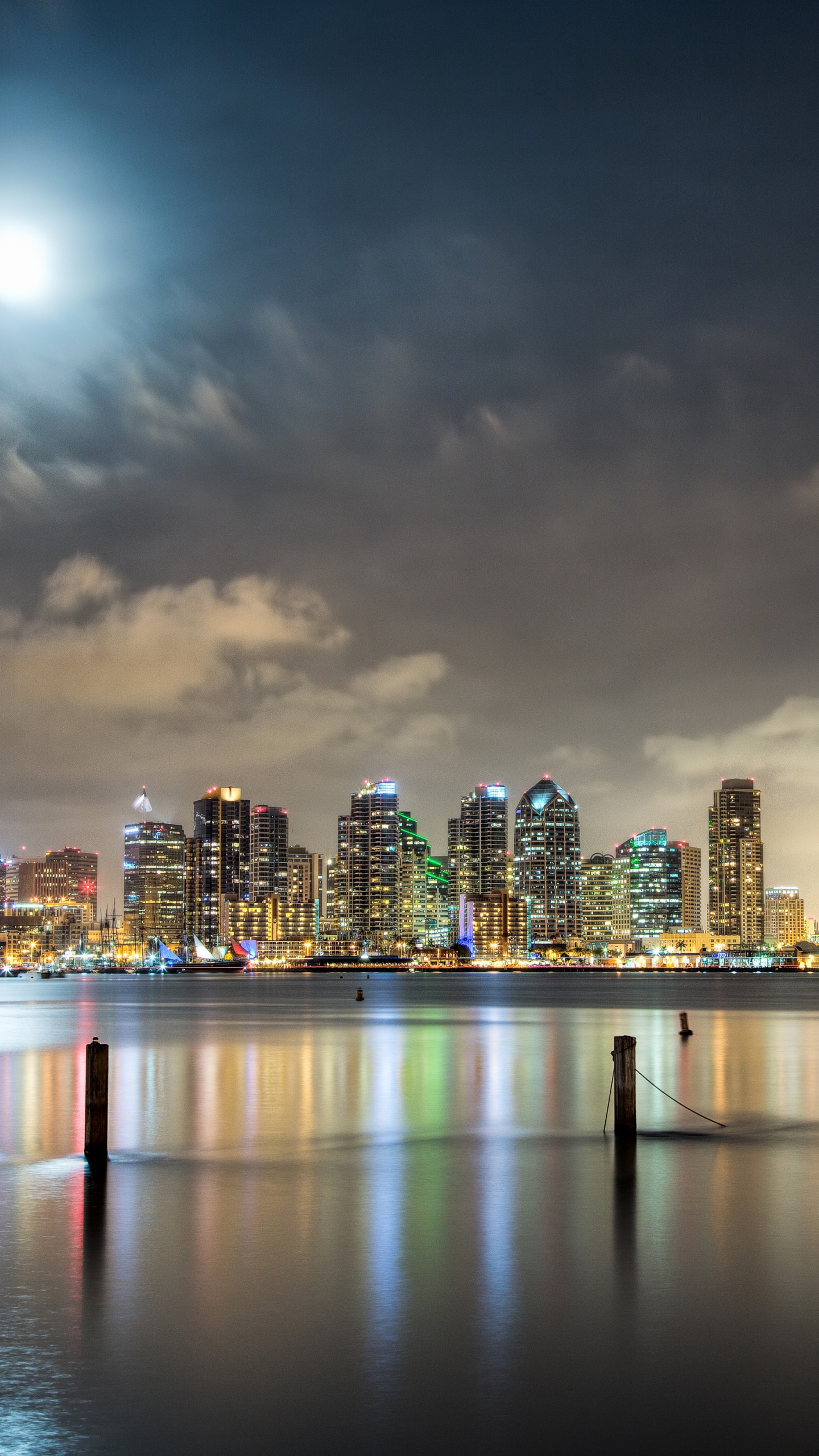 Skyline Der Stadt Über Gewässer Während Der Nacht. Wallpaper in 1440x2560 Resolution