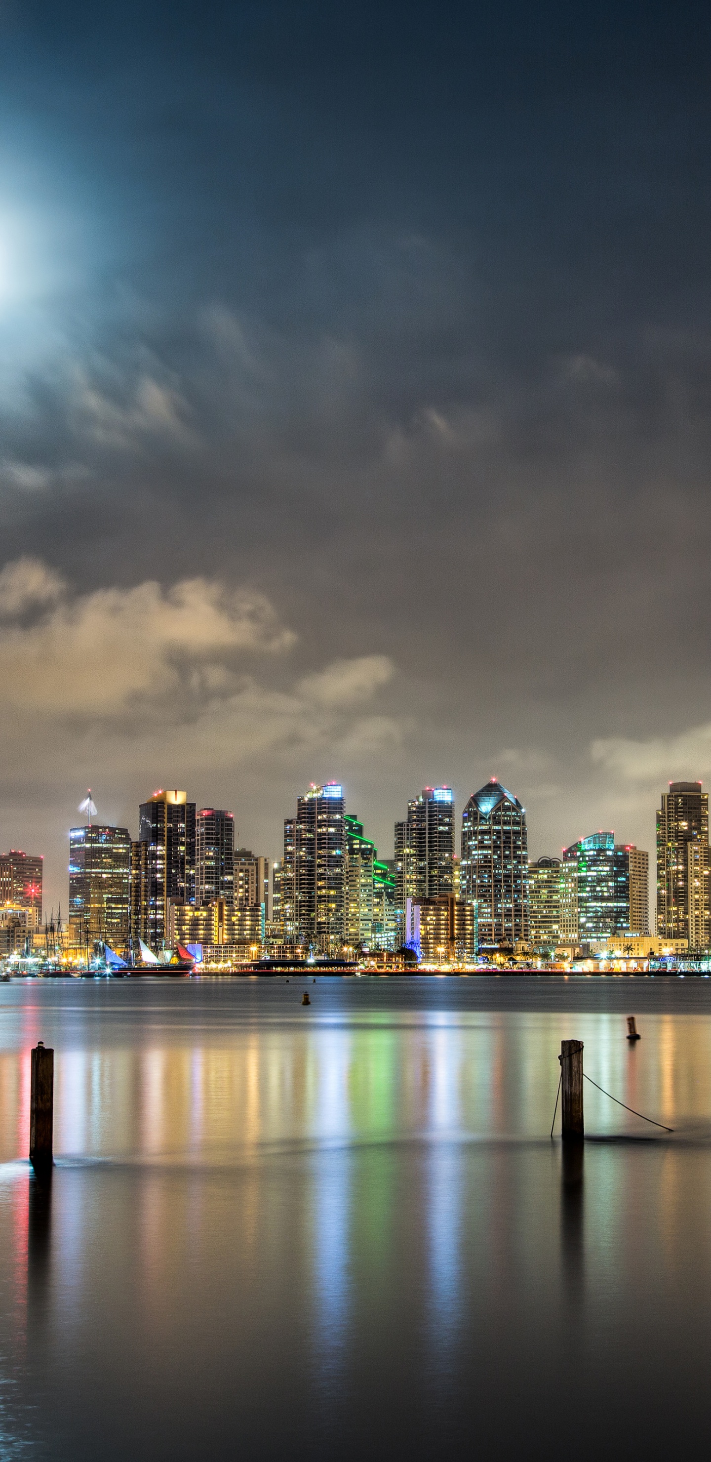 Skyline Der Stadt Über Gewässer Während Der Nacht. Wallpaper in 1440x2960 Resolution