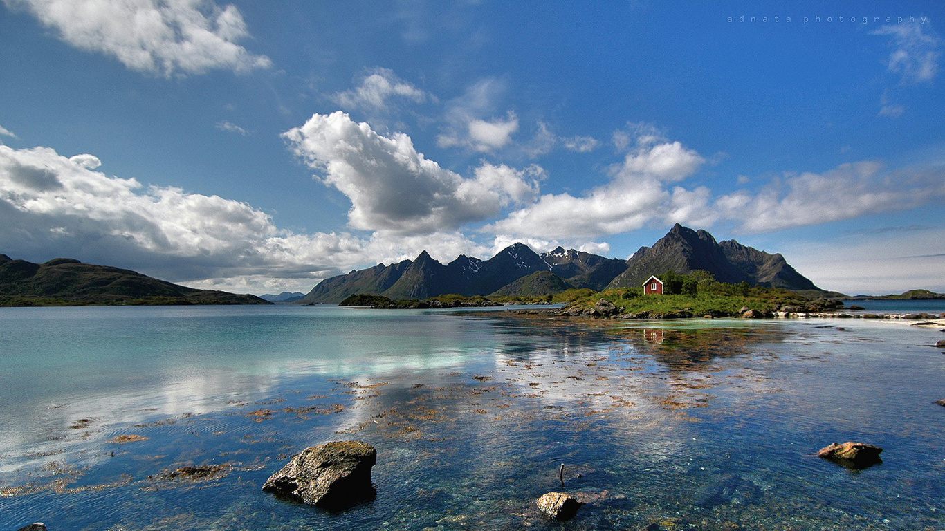 Gewässer in Der Nähe Des Berges Unter Blauem Himmel Tagsüber. Wallpaper in 1366x768 Resolution