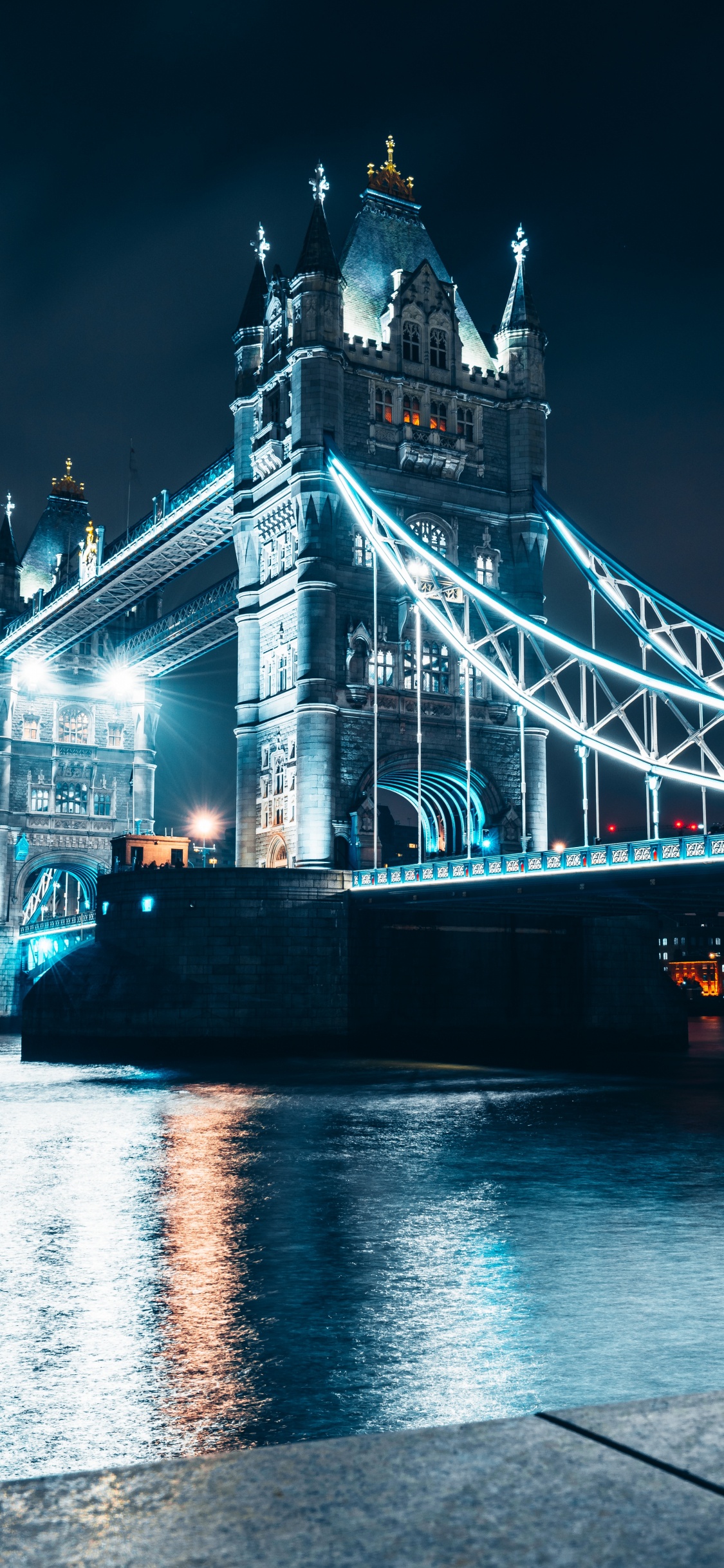 Weiße Und Blaue Brücke in Der Nähe Von Stadtgebäuden Während Der Nacht. Wallpaper in 1125x2436 Resolution
