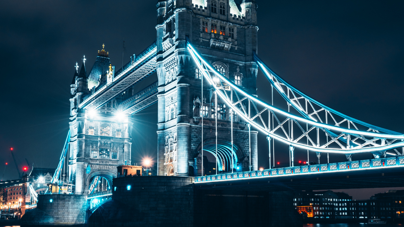 White and Blue Bridge Near City Buildings During Night Time. Wallpaper in 1366x768 Resolution