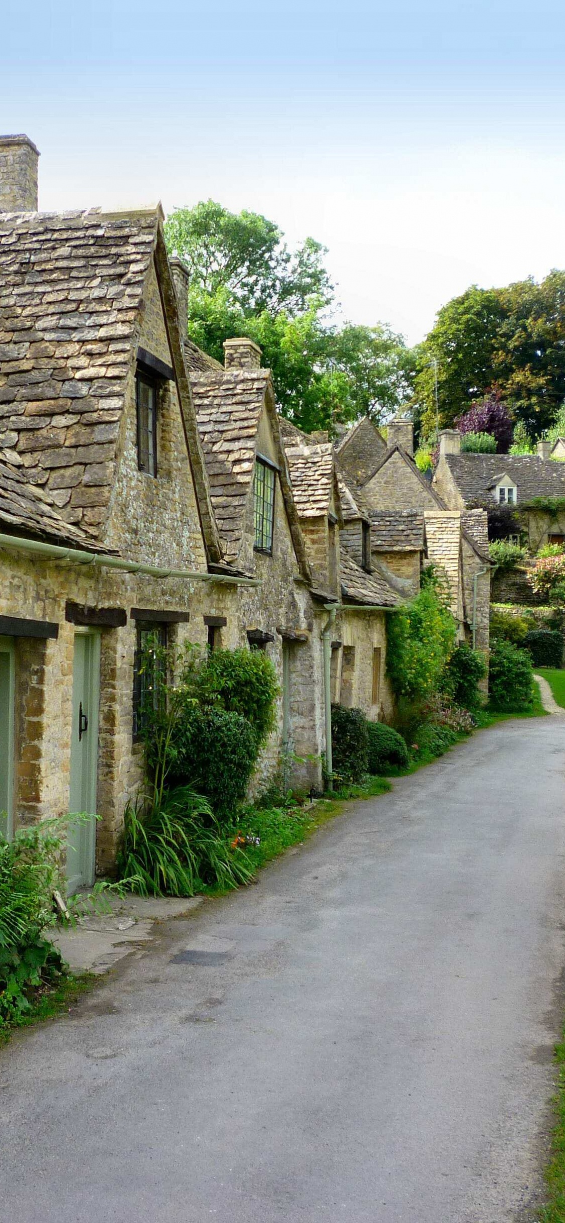 Edificio de Ladrillo Marrón Cerca Del Campo de Hierba Verde Durante el Día. Wallpaper in 1125x2436 Resolution