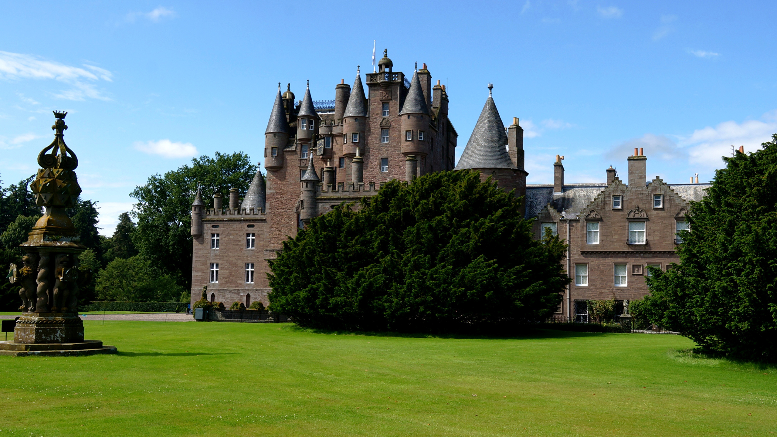 Brown Concrete Castle Surrounded by Green Grass Field Under Blue Sky During Daytime. Wallpaper in 2560x1440 Resolution
