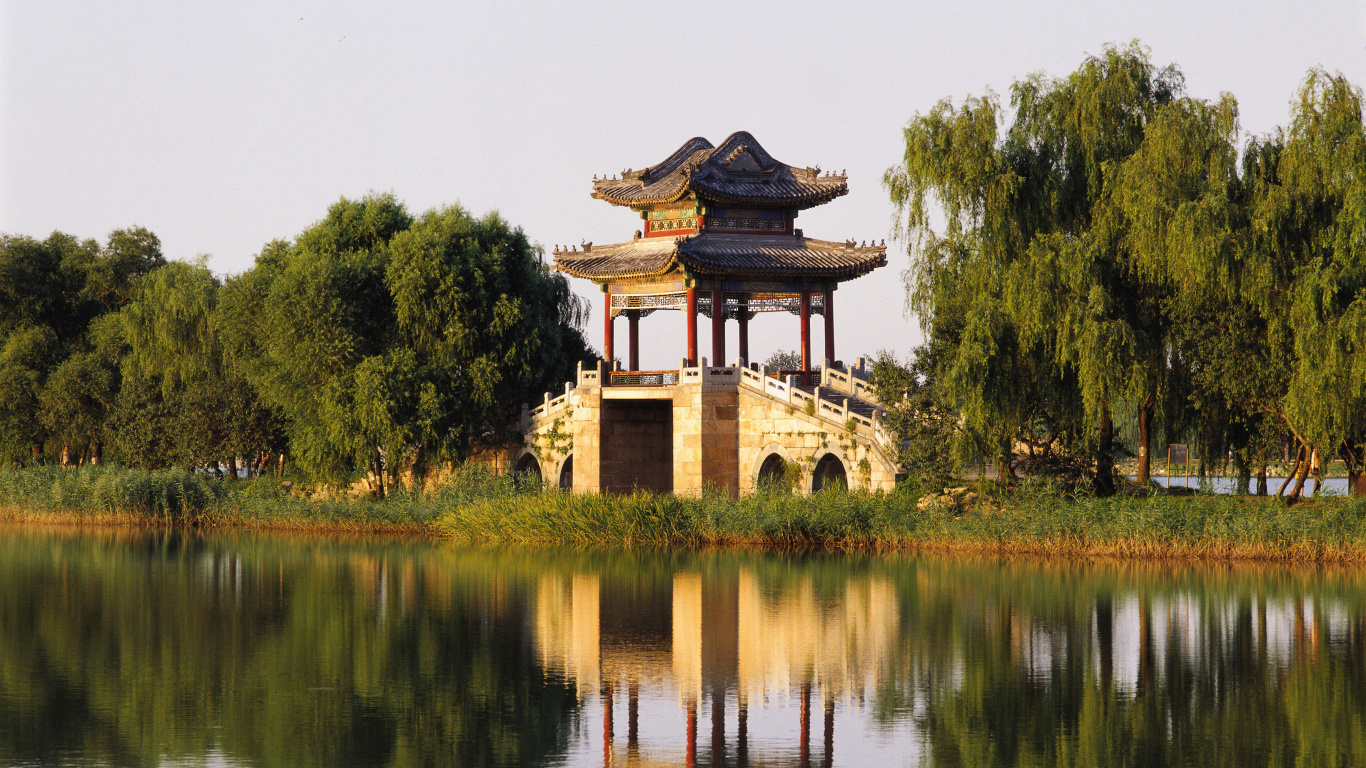 Brown and Black Concrete Building Near Green Trees and Lake During Daytime. Wallpaper in 1366x768 Resolution