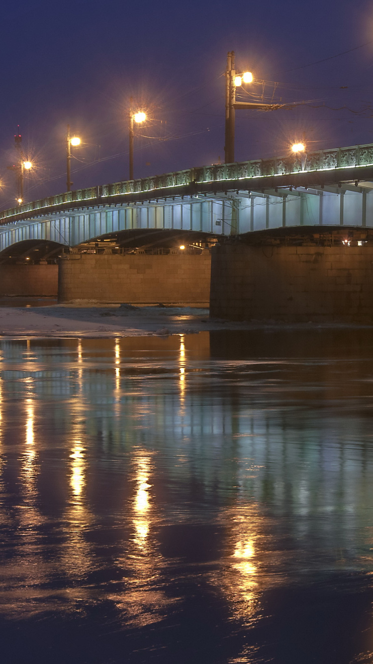 Graue Betonbrücke Über Wasser Während Der Nacht Night. Wallpaper in 750x1334 Resolution