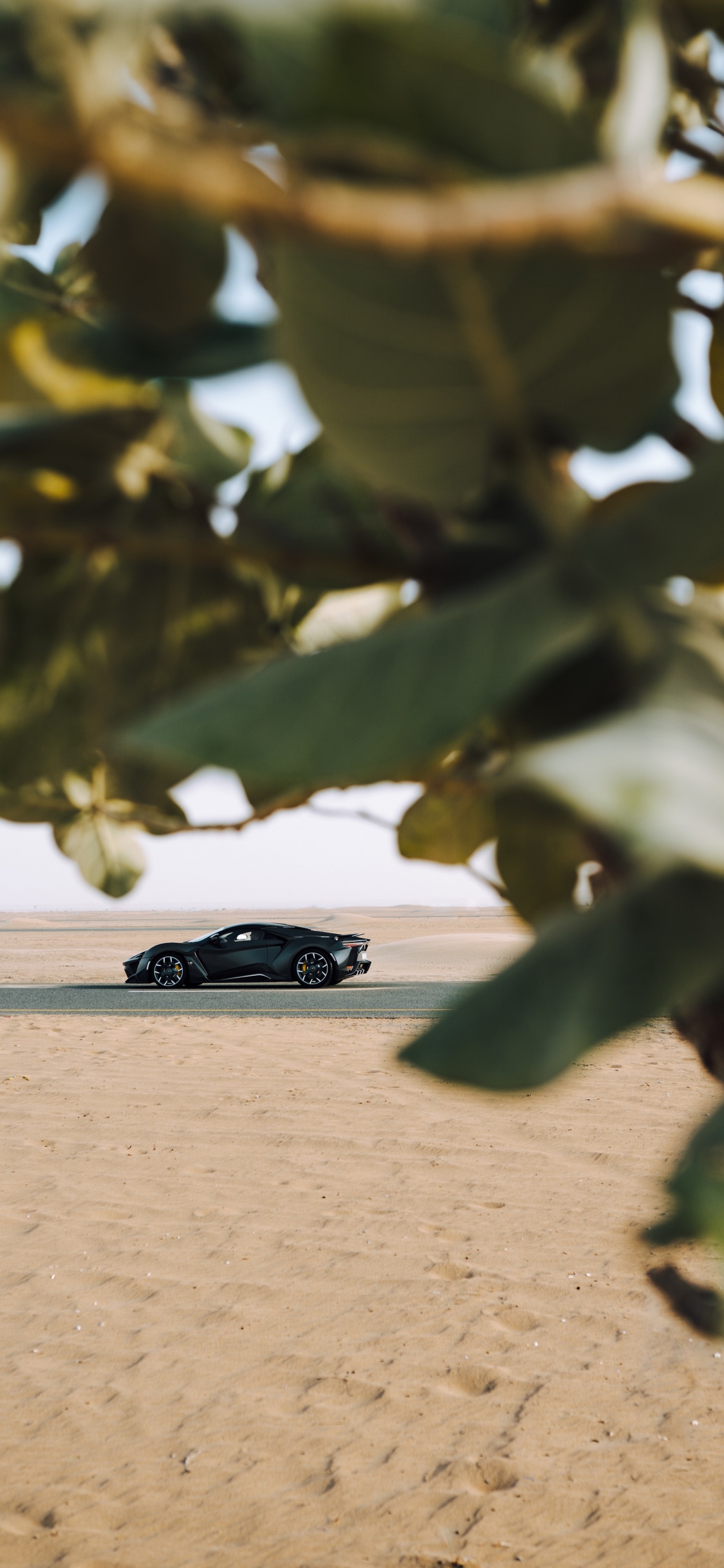 Coupé Noir Sur Sable Brun Pendant la Journée. Wallpaper in 1125x2436 Resolution