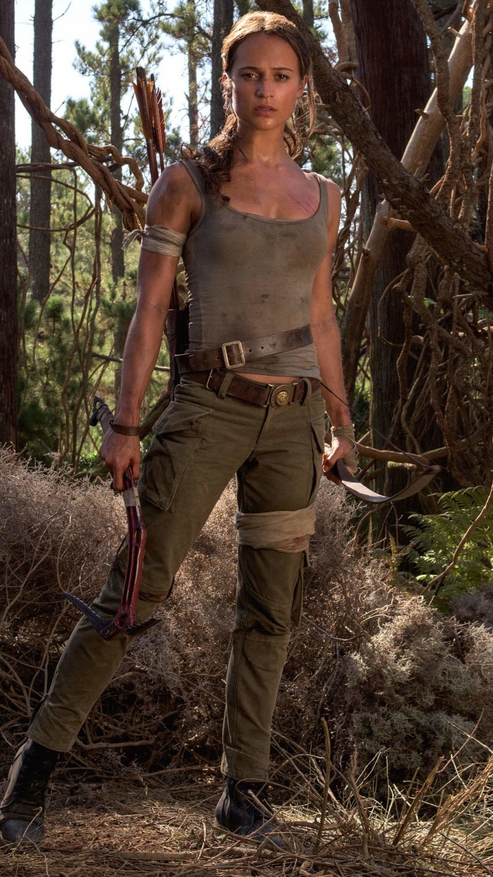 Frau in Braunem Tanktop Und Grüner Hose, Die Tagsüber Auf Braunem Baumstamm Steht. Wallpaper in 720x1280 Resolution