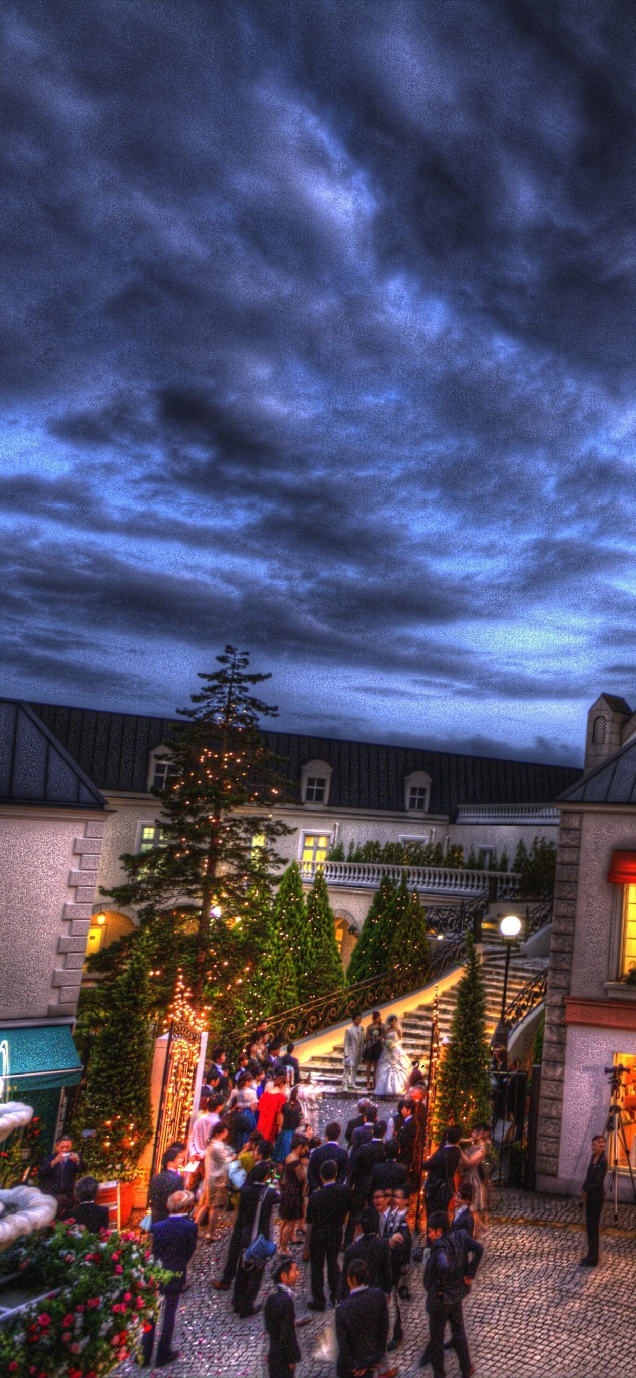 Personnes Marchant Dans la Rue Près du Bâtiment Pendant la Nuit. Wallpaper in 1242x2688 Resolution