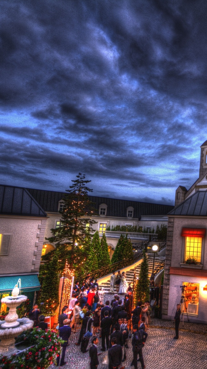 Leute, Die Nachts Auf Der Straße in Der Nähe Des Gebäudes Gehen. Wallpaper in 720x1280 Resolution