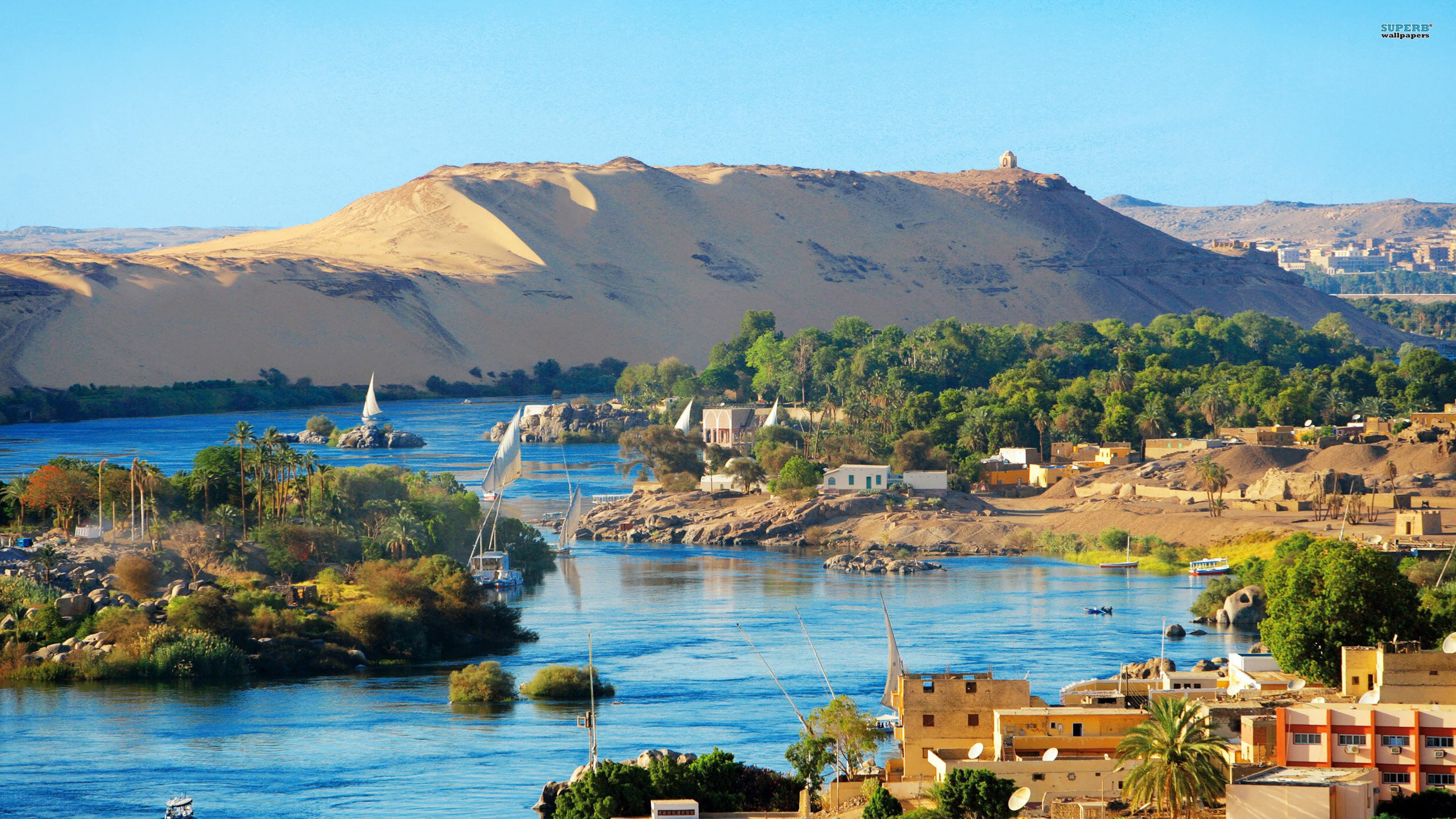 White and Brown Concrete Buildings Near Body of Water During Daytime. Wallpaper in 2560x1440 Resolution