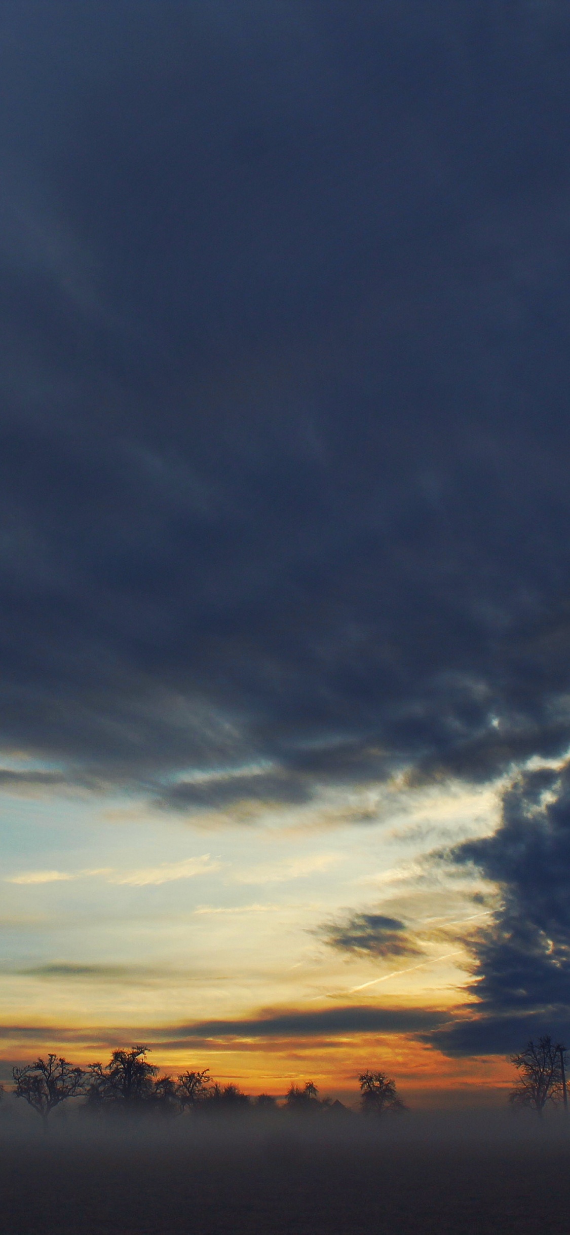 Silhouette Von Bäumen Unter Bewölktem Himmel Bei Sonnenuntergang. Wallpaper in 1125x2436 Resolution