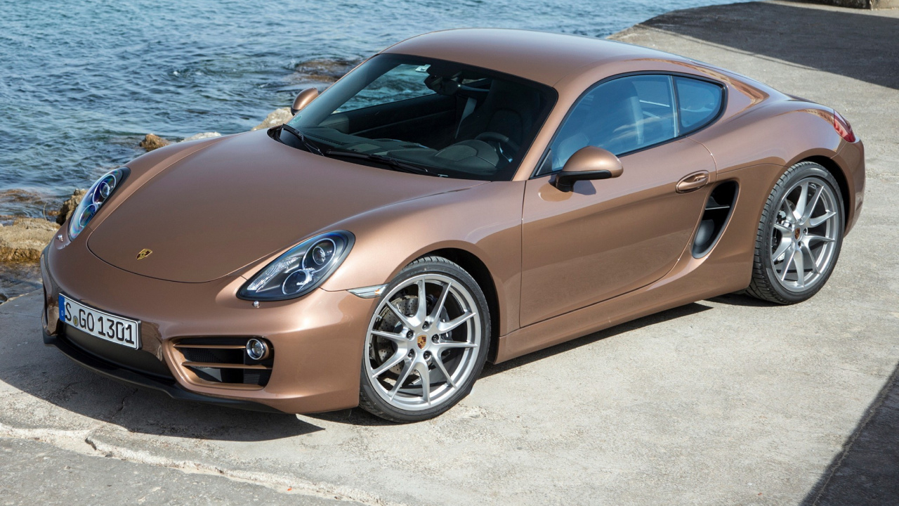 Brauner Porsche 911 Geparkt Auf Grauem Sand in Der Nähe Eines Gewässers Tagsüber. Wallpaper in 1280x720 Resolution