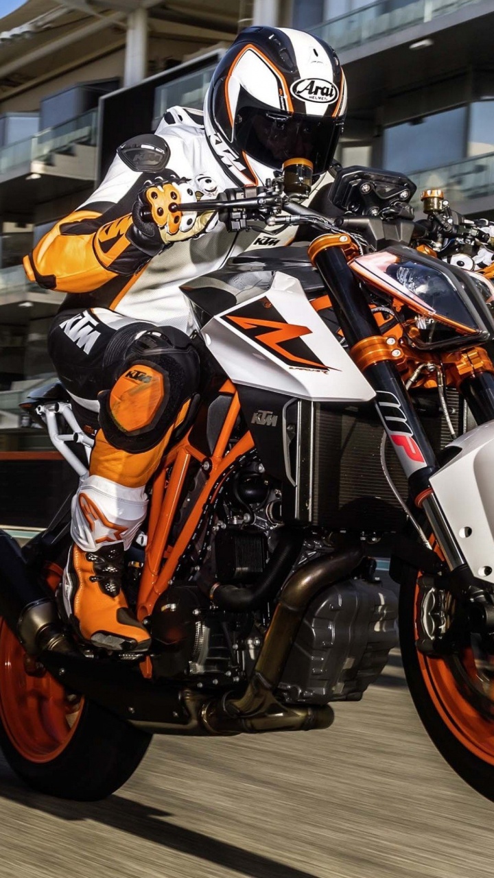 Mann Mit Orangefarbenem Helm, Der Ein Orangefarbenes Und Schwarzes Motorrad Fährt. Wallpaper in 720x1280 Resolution